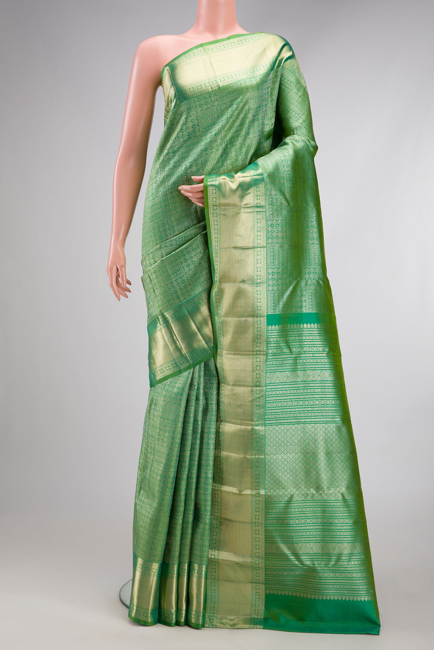 Green Kanchipuram Silk Saree with Zari Brocade on the body and Zari Border.  displayed on a mannequin