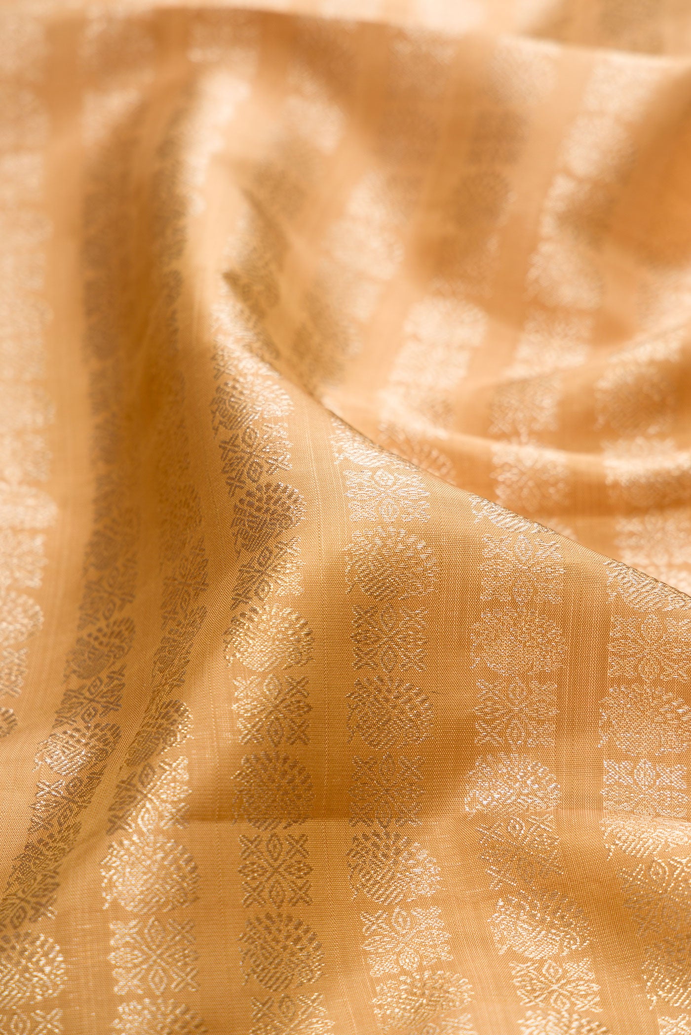 Close up of Gold Kanchipuram Silk Saree with Zari Brocade on the body and Zari Border.  displaying folds