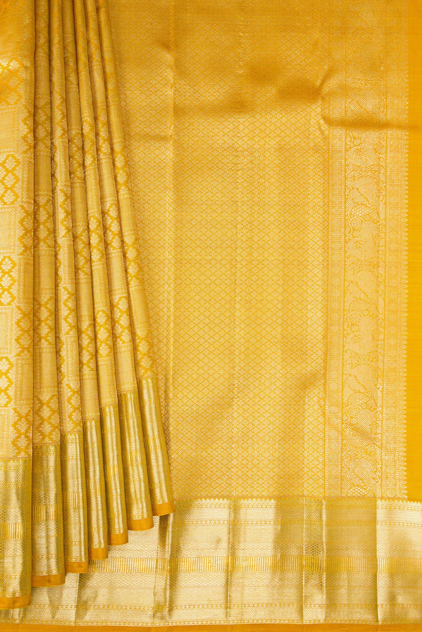 Pleats and pallu of Mustard Kanchipuram Silk Saree with Zari Brocade on the body and Zari Border. 
