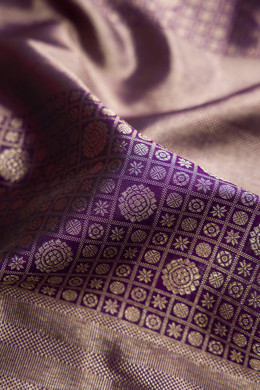 Close up of Violet Dual Tone Kanchipuram Silk Saree with Zari Brocade on the body and Zari Border.  displaying folds