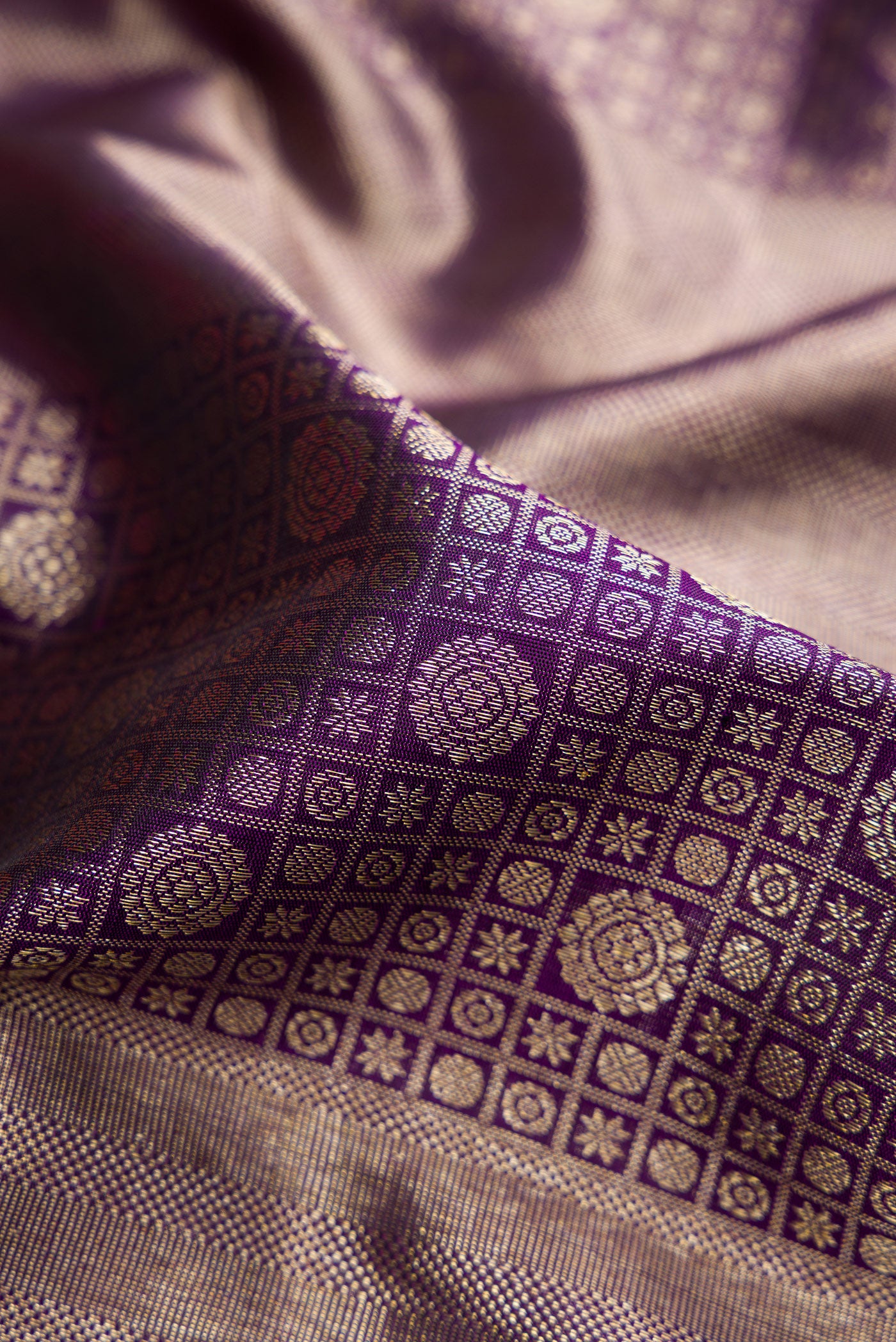 Close up of Violet Dual Tone Kanchipuram Silk Saree with Zari Brocade on the body and Zari Border.  displaying folds
