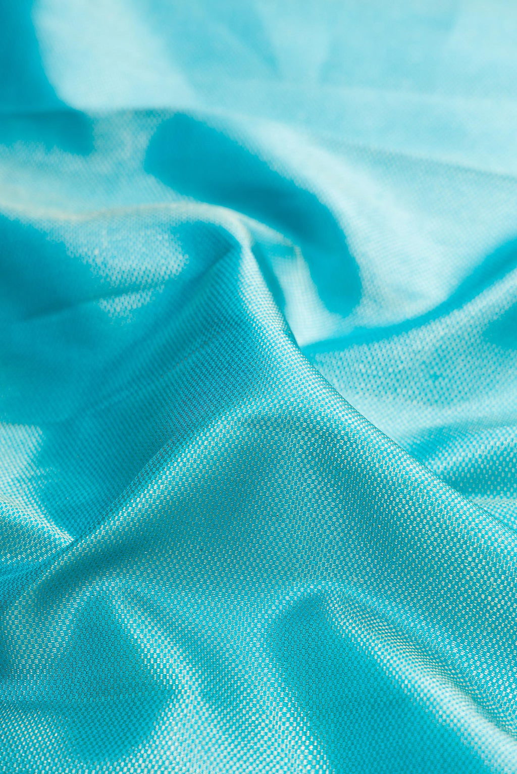 Close up of Sky Blue Kanchipuram Silk Saree with Zari Brocade on the body and Zari Border.  displaying folds