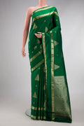 Bottle Green Kanjivaram Silk Saree with Zari Butta on the body and Zari Border.  displayed on a mannequin