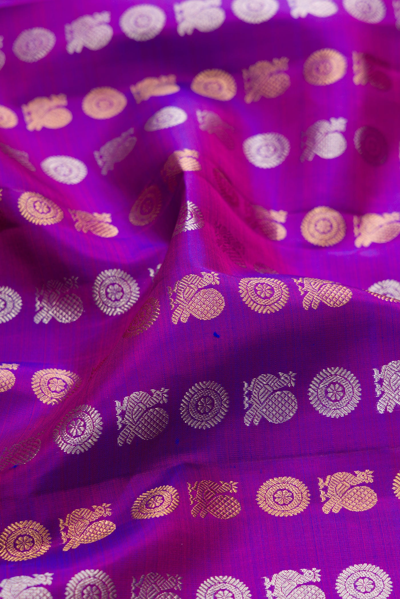 Close up of Purple Kanjivaram Silk Saree with Zari Butta on the body and Zari Border.  displaying folds