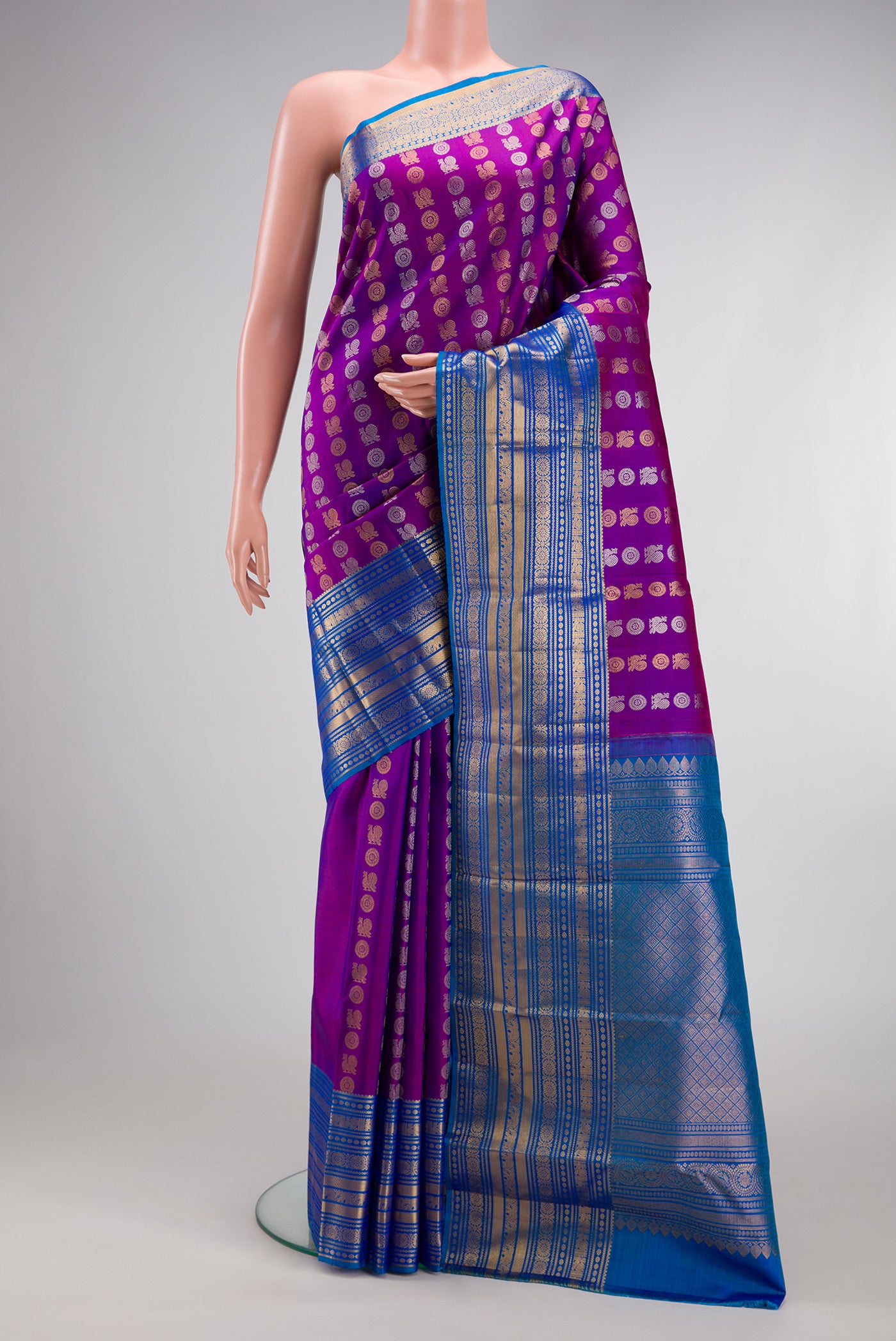 Purple Kanjivaram Silk Saree with Zari Butta on the body and Zari Border.  displayed on a mannequin