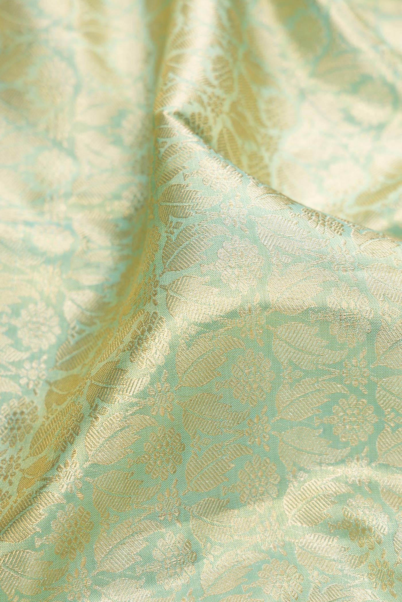 Close up of Sky Blue Dual Tone Kanchipuram Tissue Silk Saree with Zari Brocade on the body and Zari Border.  displaying folds