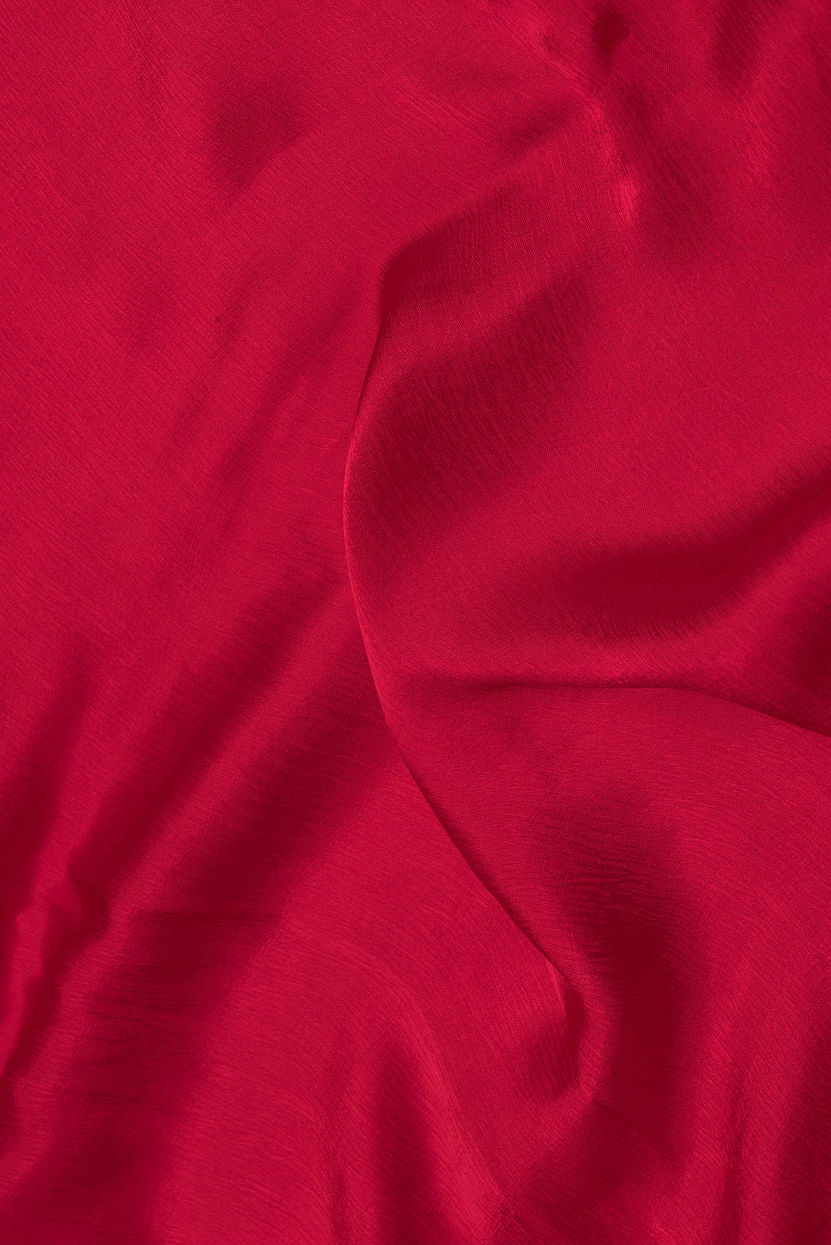 Close up of Red Satin Crepe Saree with Plain Body and Embroidery Border.  displaying folds