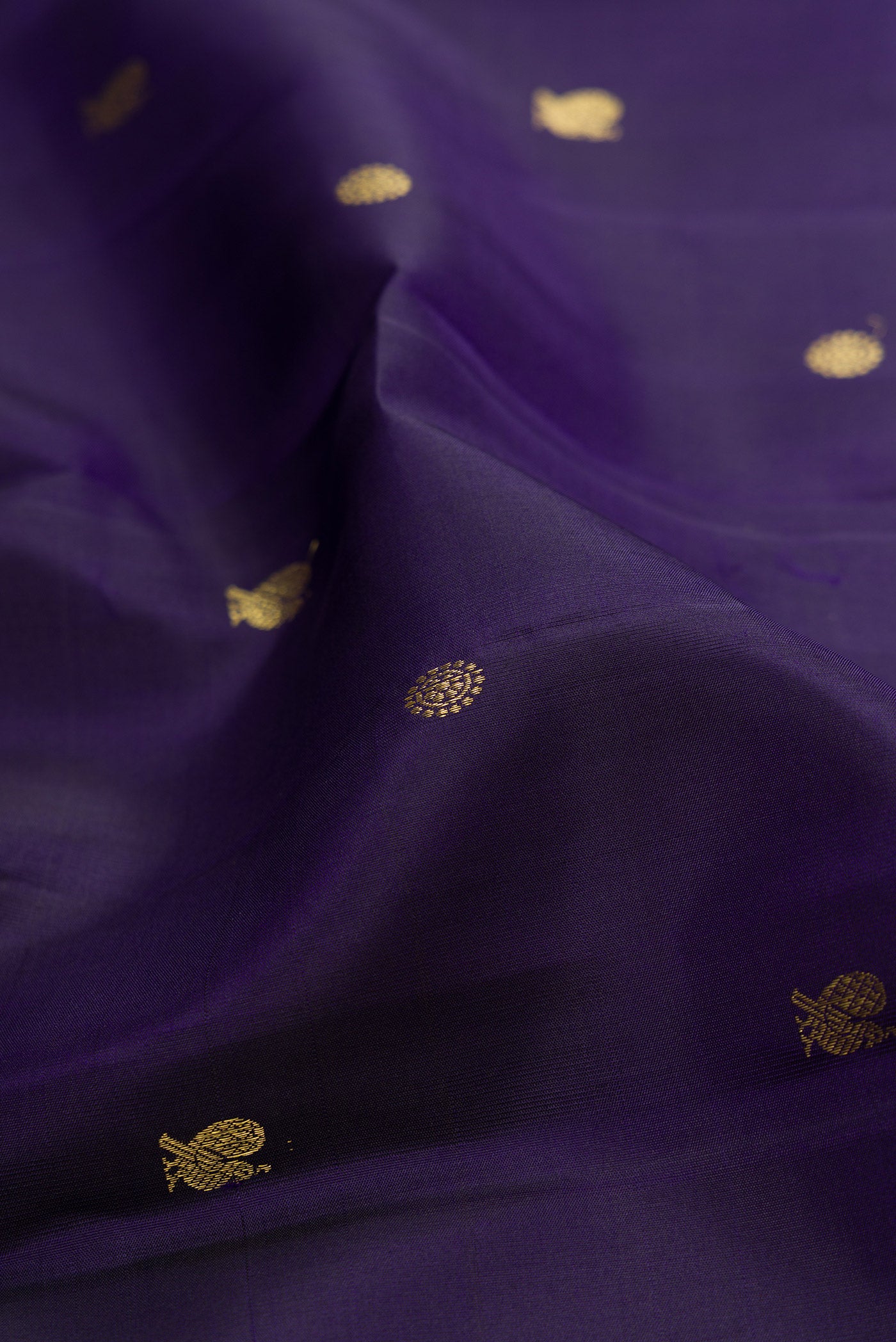 Close up of Navy Blue Kanchipuram Silk Saree with Zari Butta on the body and Zari Border.  displaying folds