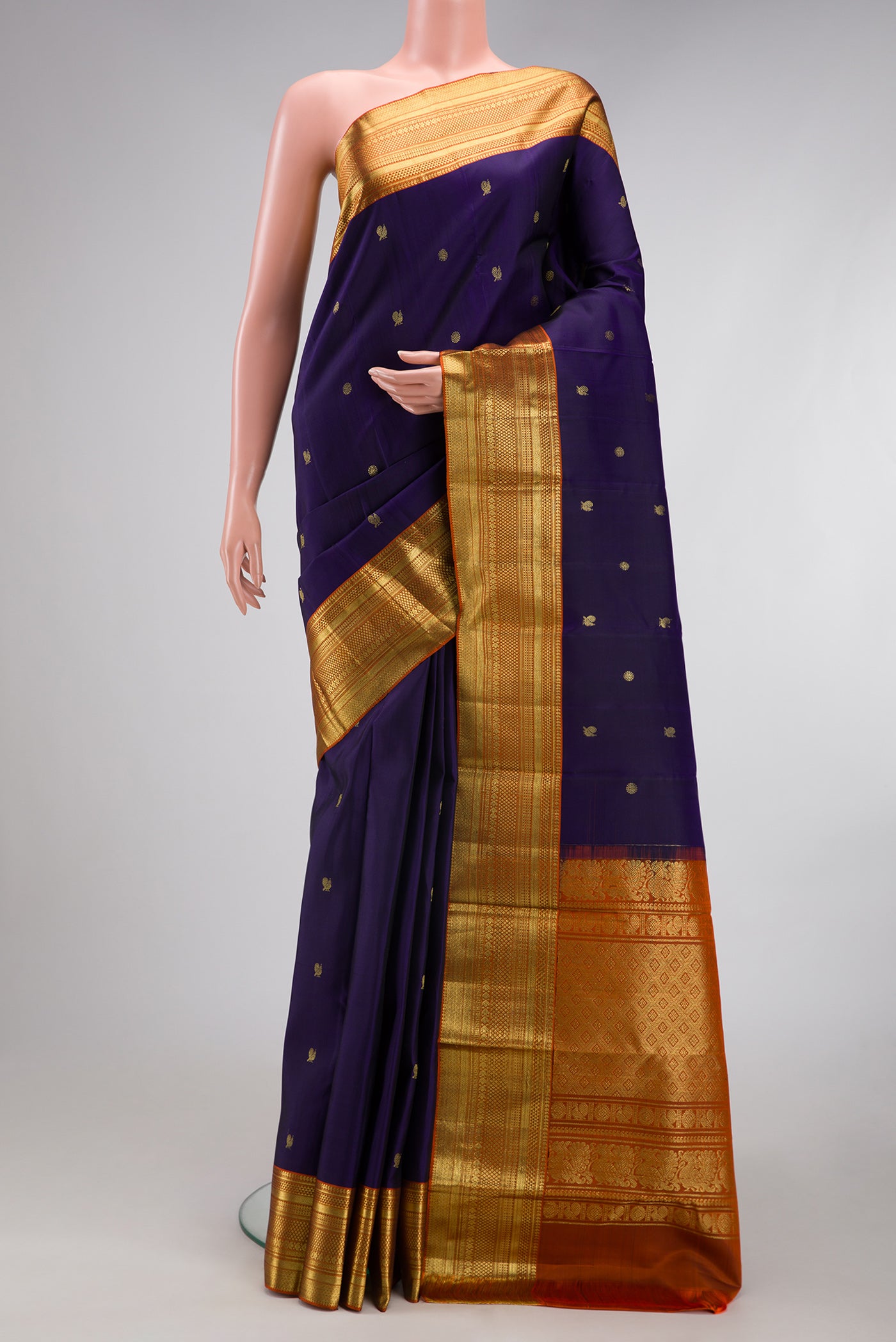 Navy Blue Kanchipuram Silk Saree with Zari Butta on the body and Zari Border.  displayed on a mannequin