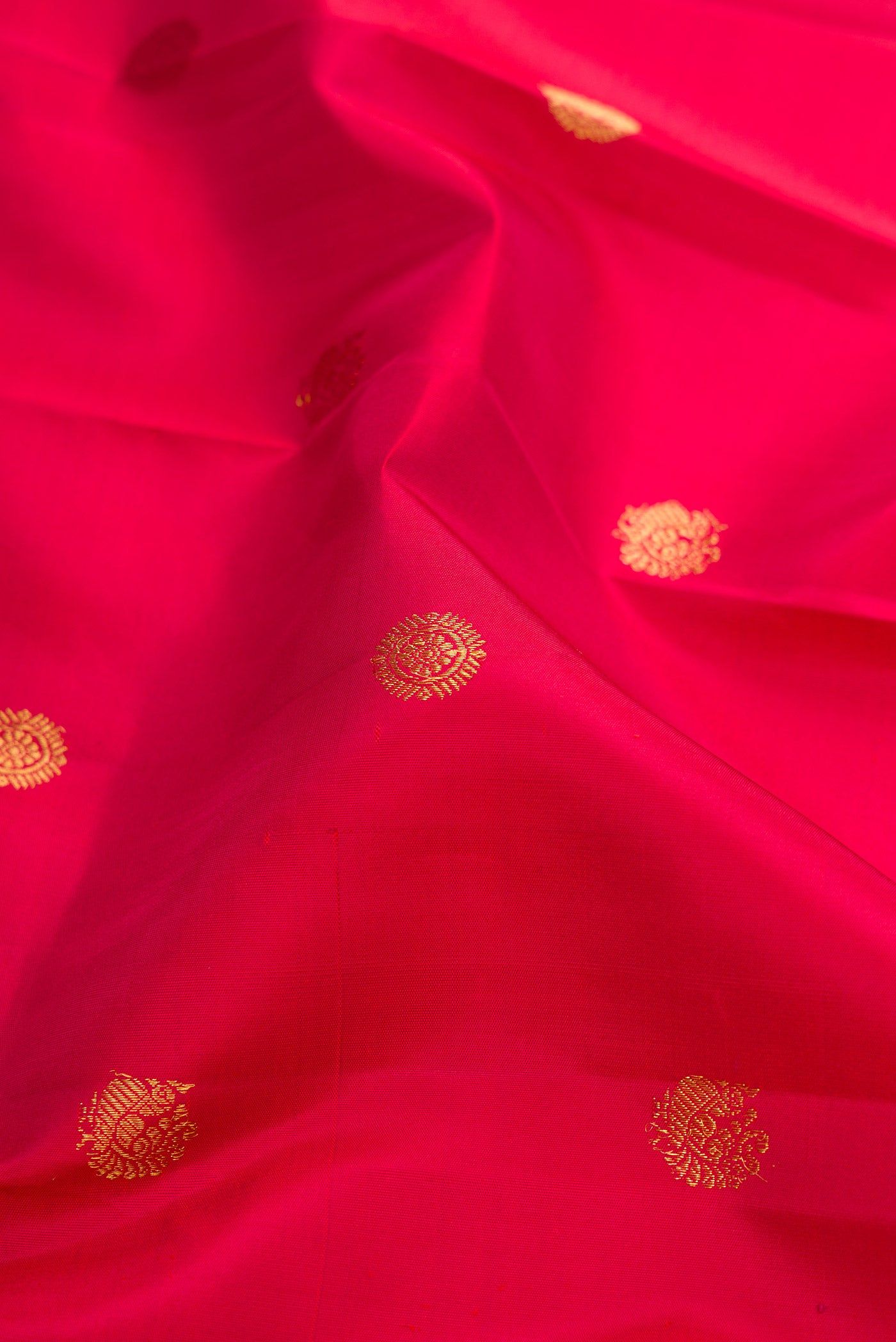 Close up of Maroon Kanchipuram Silk Saree with Zari Butta on the body and Zari Border.  displaying folds
