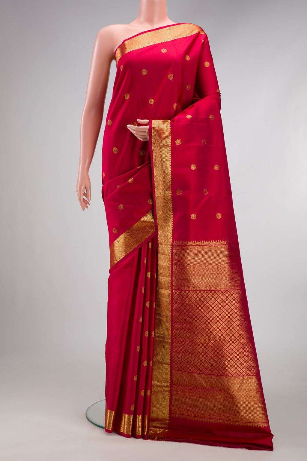 Maroon Kanchipuram Silk Saree with Zari Butta on the body and Zari Border.  displayed on a mannequin