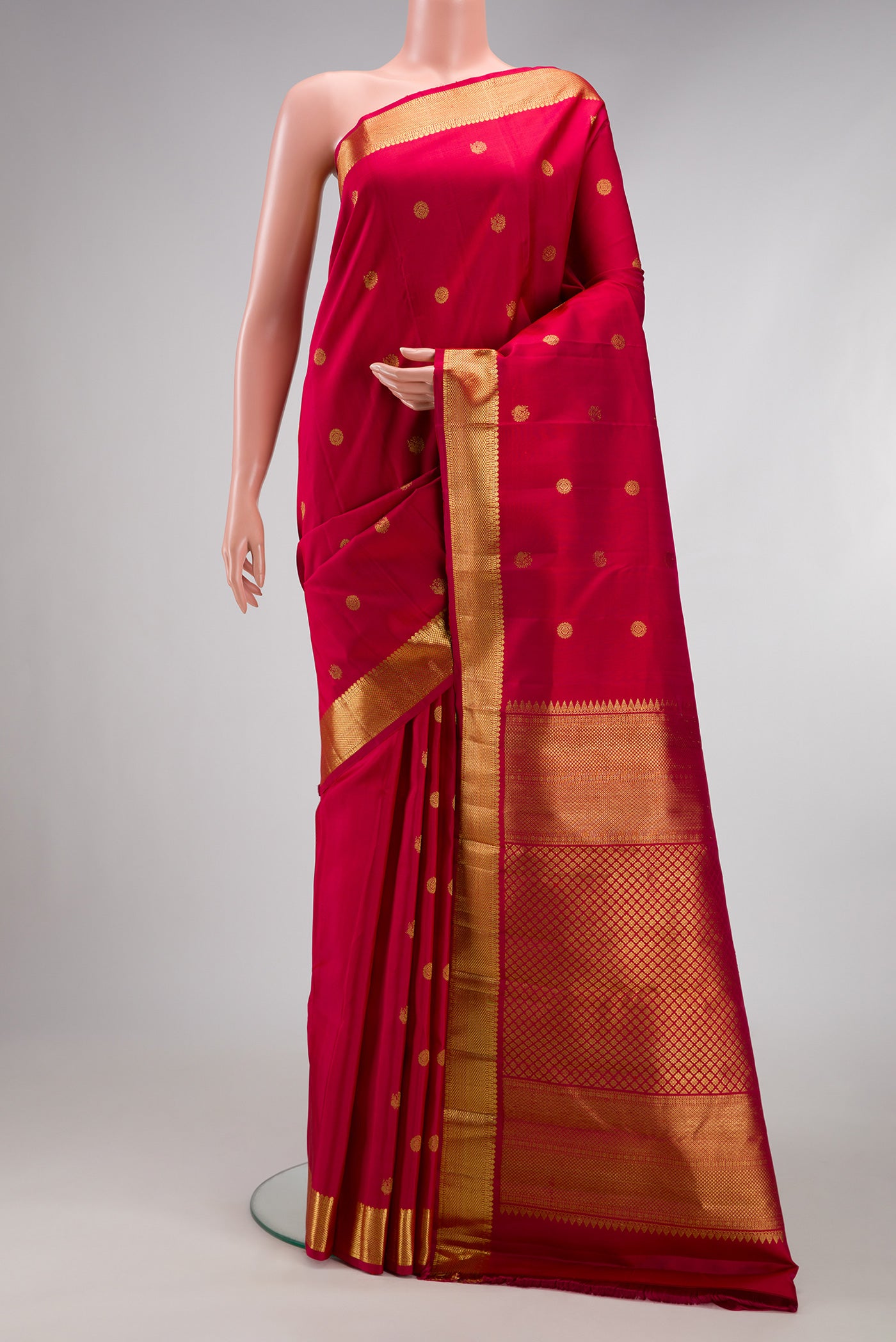 Maroon Kanchipuram Silk Saree with Zari Butta on the body and Zari Border.  displayed on a mannequin