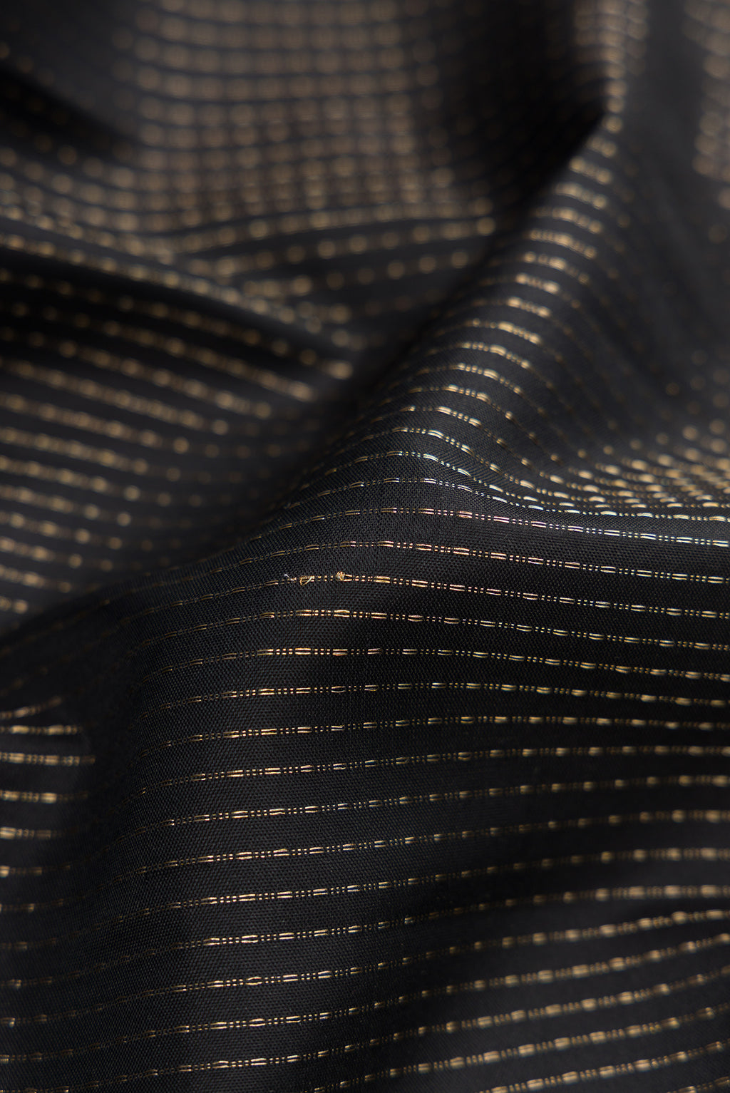 Close up of Black Soft Silk Saree with Stripes on the body and Zari Border.  displaying folds