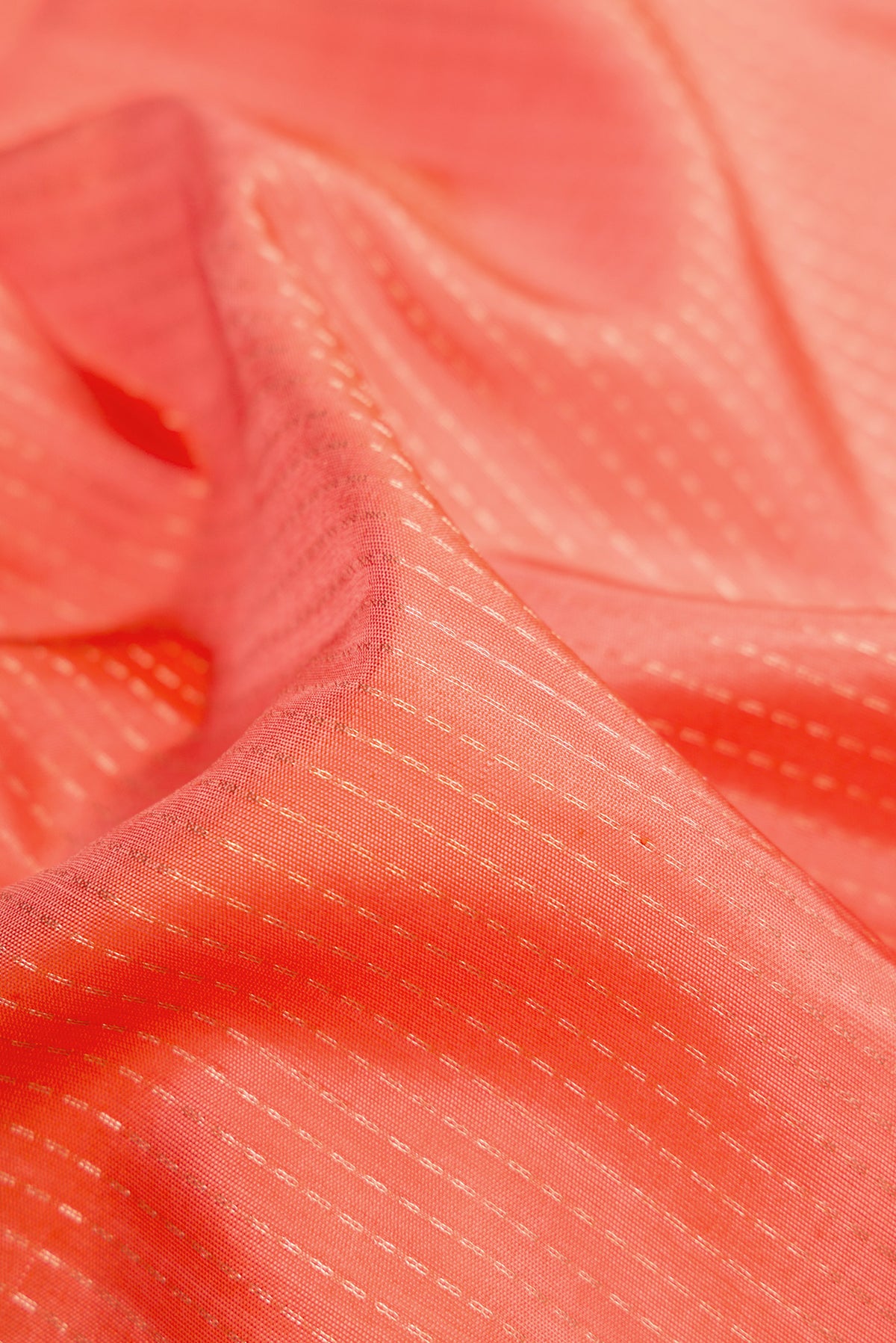 Close up of Golden Peach Soft Silk Saree with Stripes on the body and Zari Border.  displaying folds