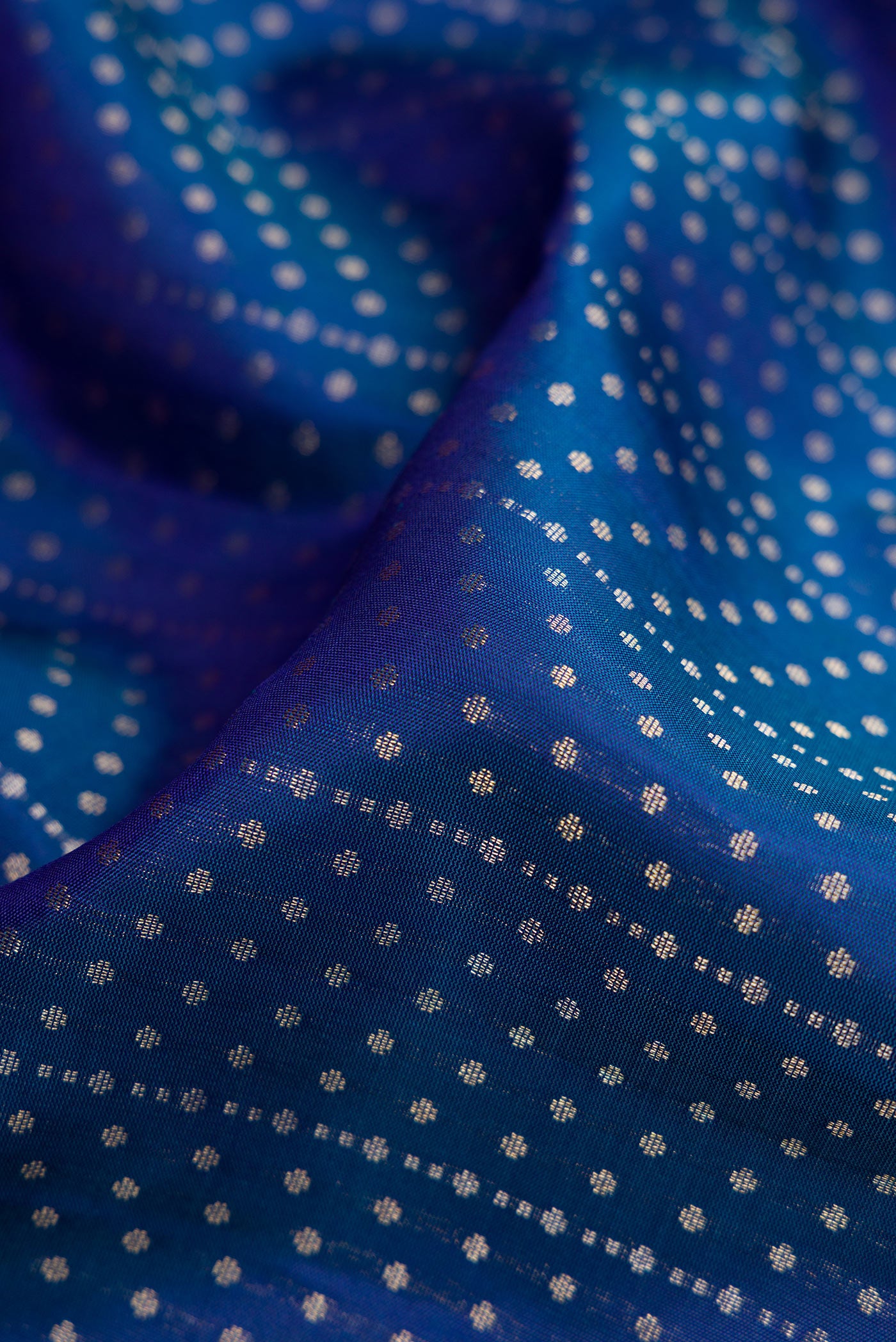 Close up of Peacock Blue Dual Tone Soft Silk Saree with Zari Butta on the body and Zari Border.  displaying folds