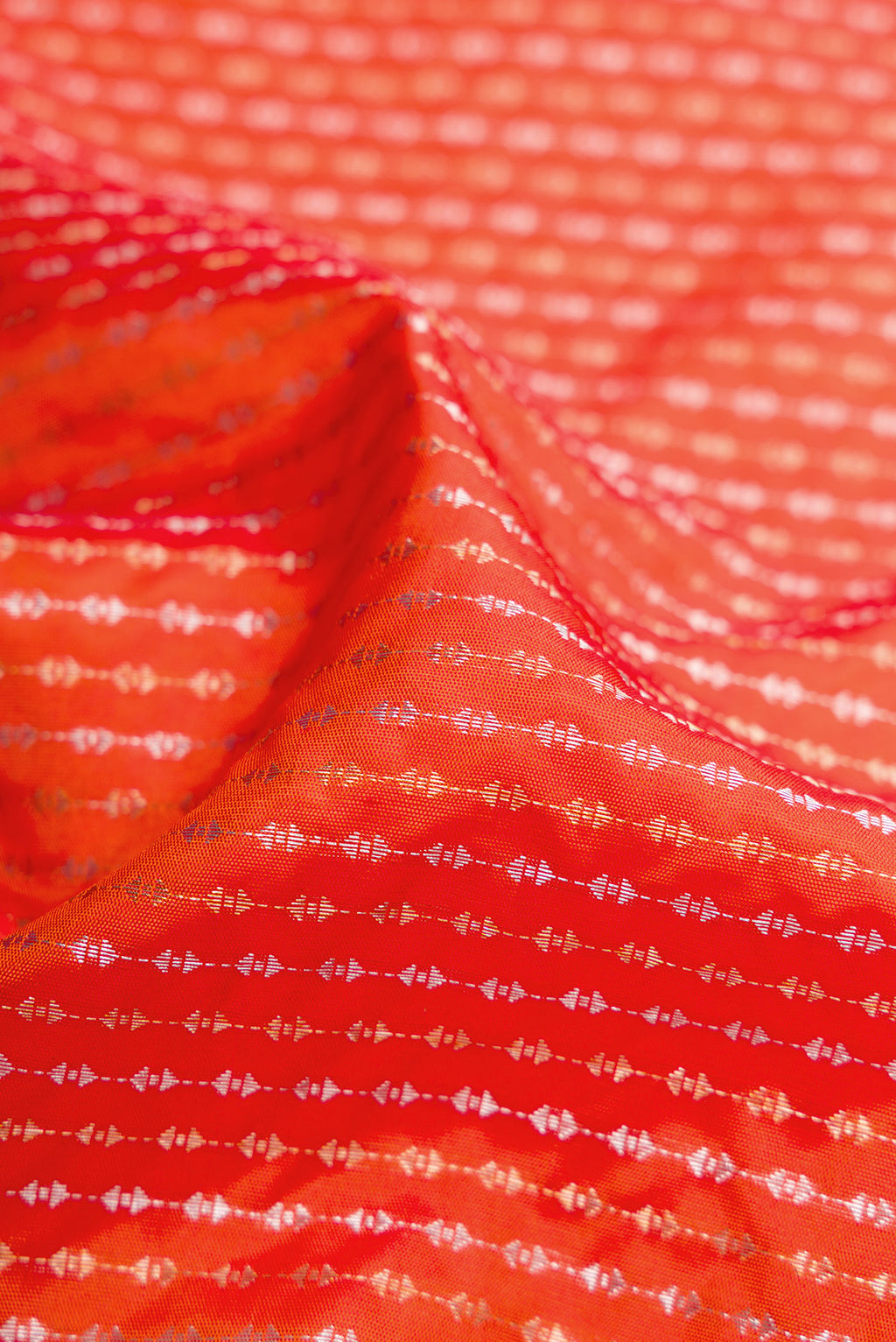 Close up of Orange Dual Tone Soft Silk Saree with Stripes on the body and Plain Border.  displaying folds