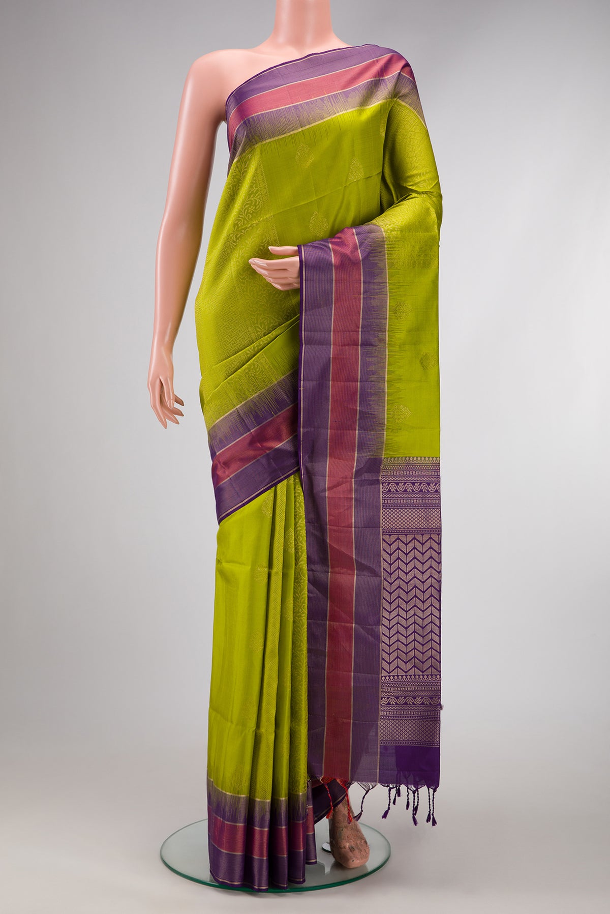 Parrot Green Soft Silk Saree with Zari Butta on the body and Fancy Border.  displayed on a mannequin