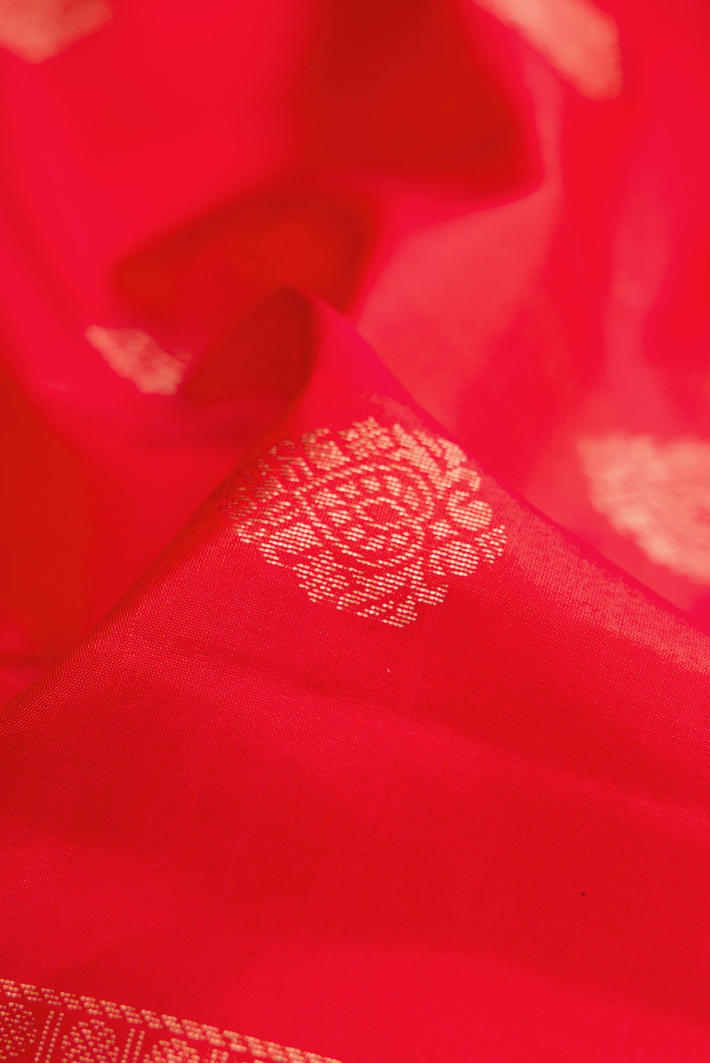 Close up of Orange Dual Tone Soft Silk Saree with Zari Butta on the body and Zari Border.  displaying folds