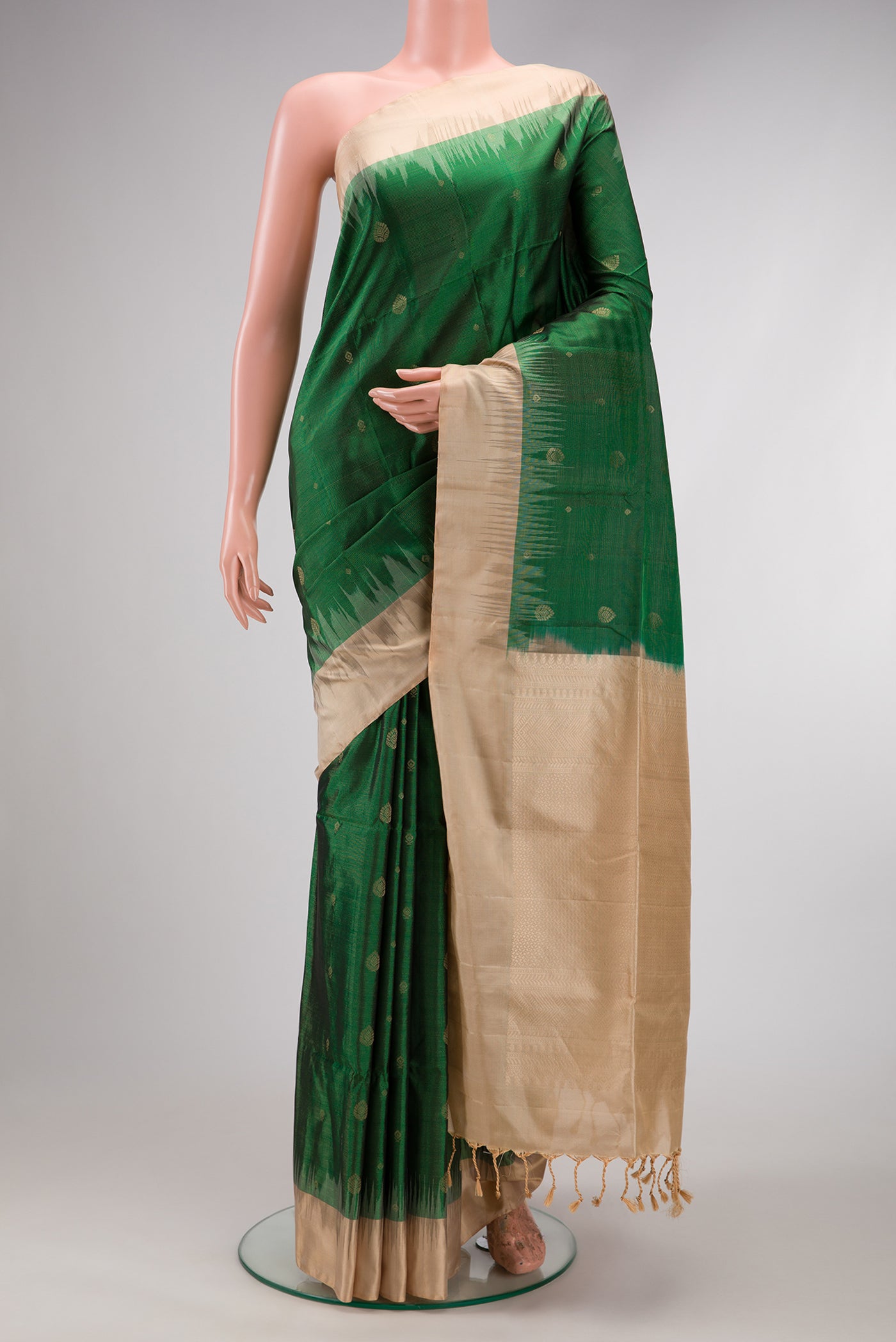 Green Soft Silk Saree with Zari Butta on the body and Zari Border.  displayed on a mannequin