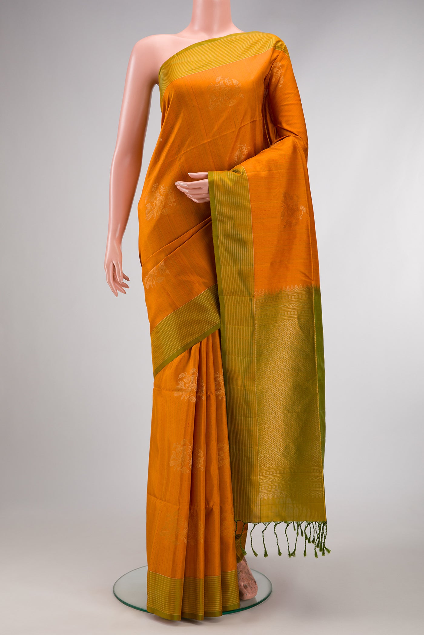 Orange Soft Silk Saree with Zari Butta on the body and Fancy Border.  displayed on a mannequin