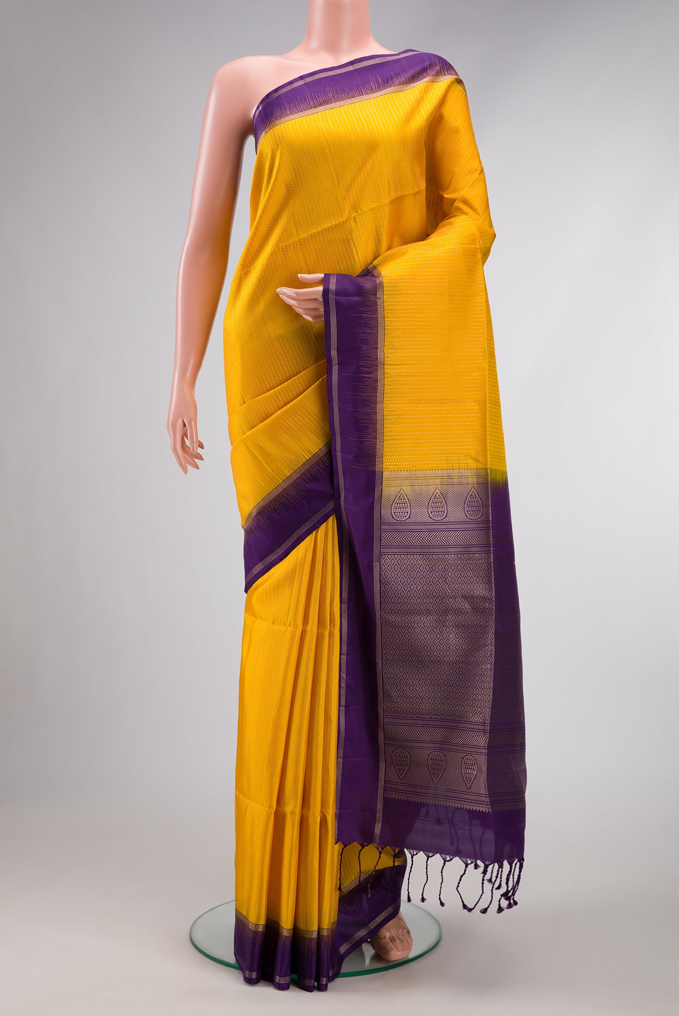 Mustard Soft Silk Saree with Stripes on the body and Zari Border.  displayed on a mannequin