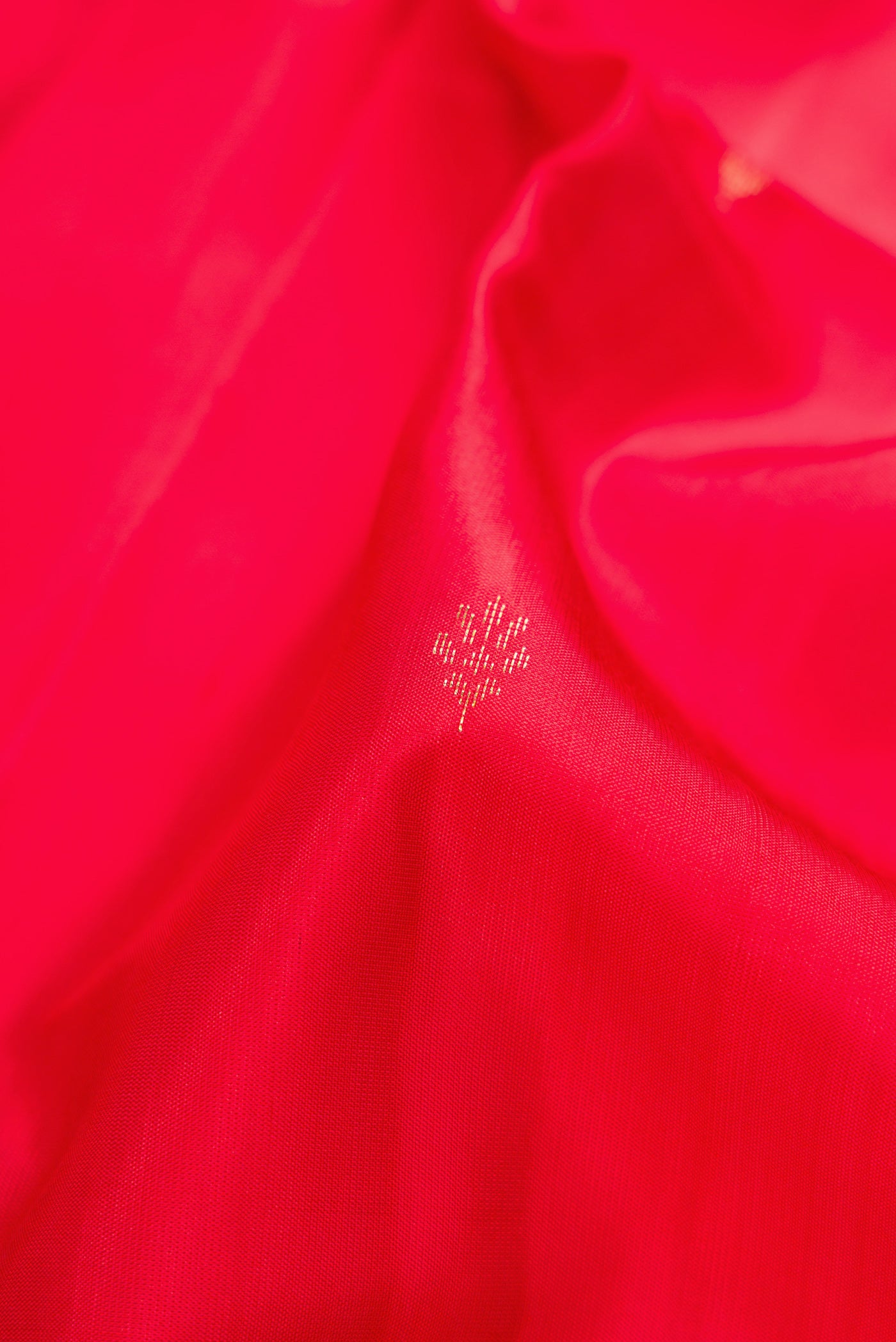Close up of Red Dual Tone Soft Silk Saree with Zari Butta on the body and Fancy Border.  displaying folds