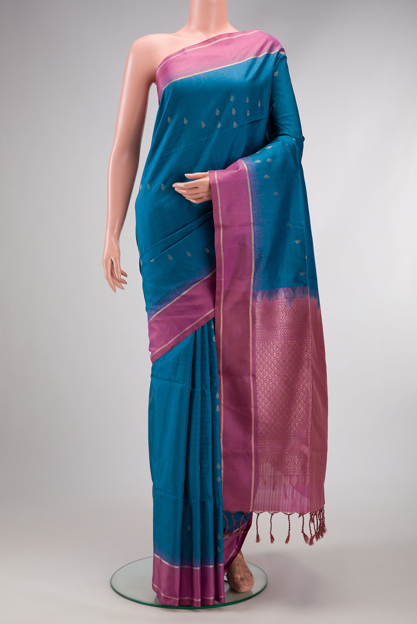 Peacock Blue Dual Tone Soft Silk Saree with Zari Butta on the body and Zari Border.  displayed on a mannequin