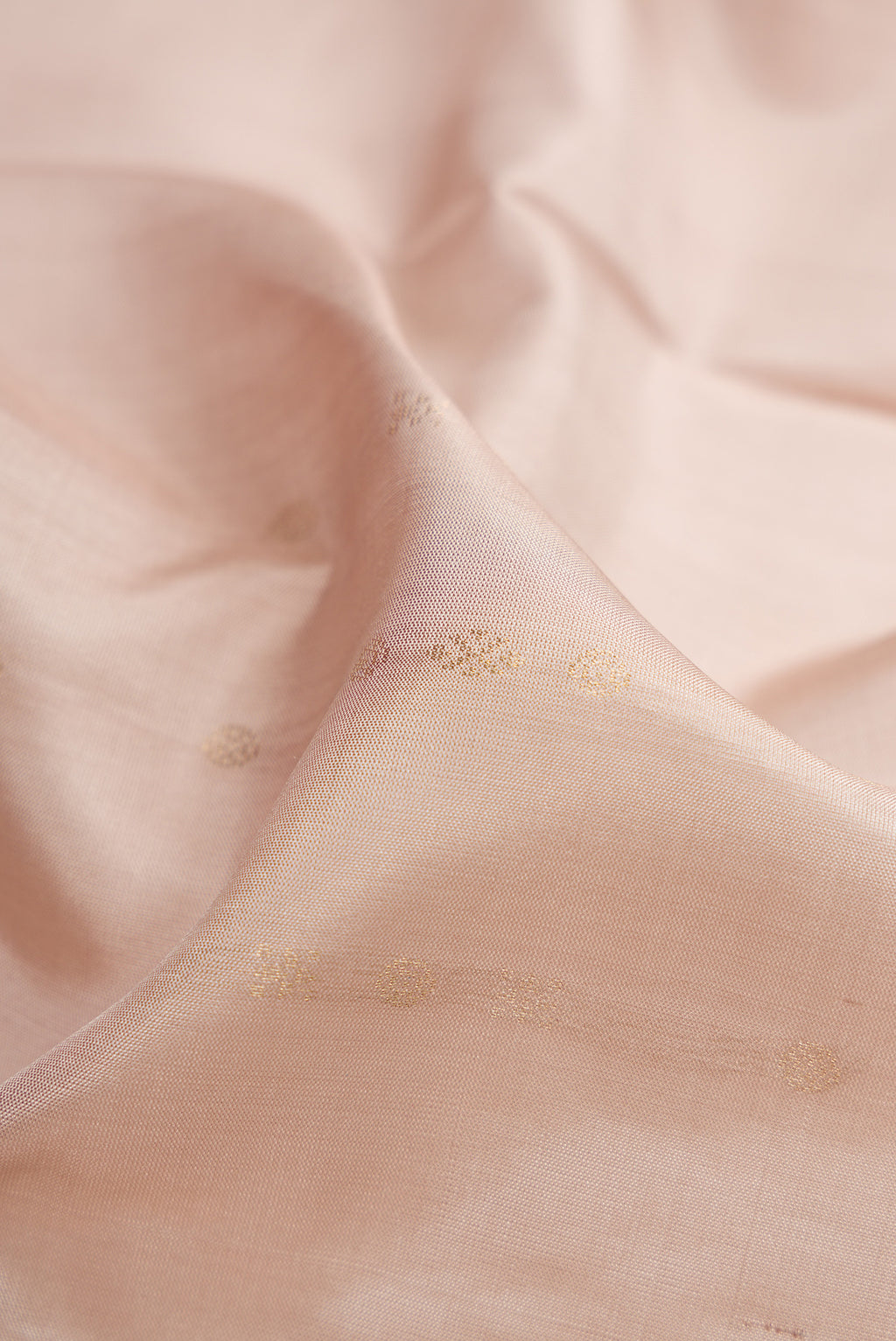 Close up of Beige Soft Silk Saree with Zari Butta on the body and Zari Border.  displaying folds