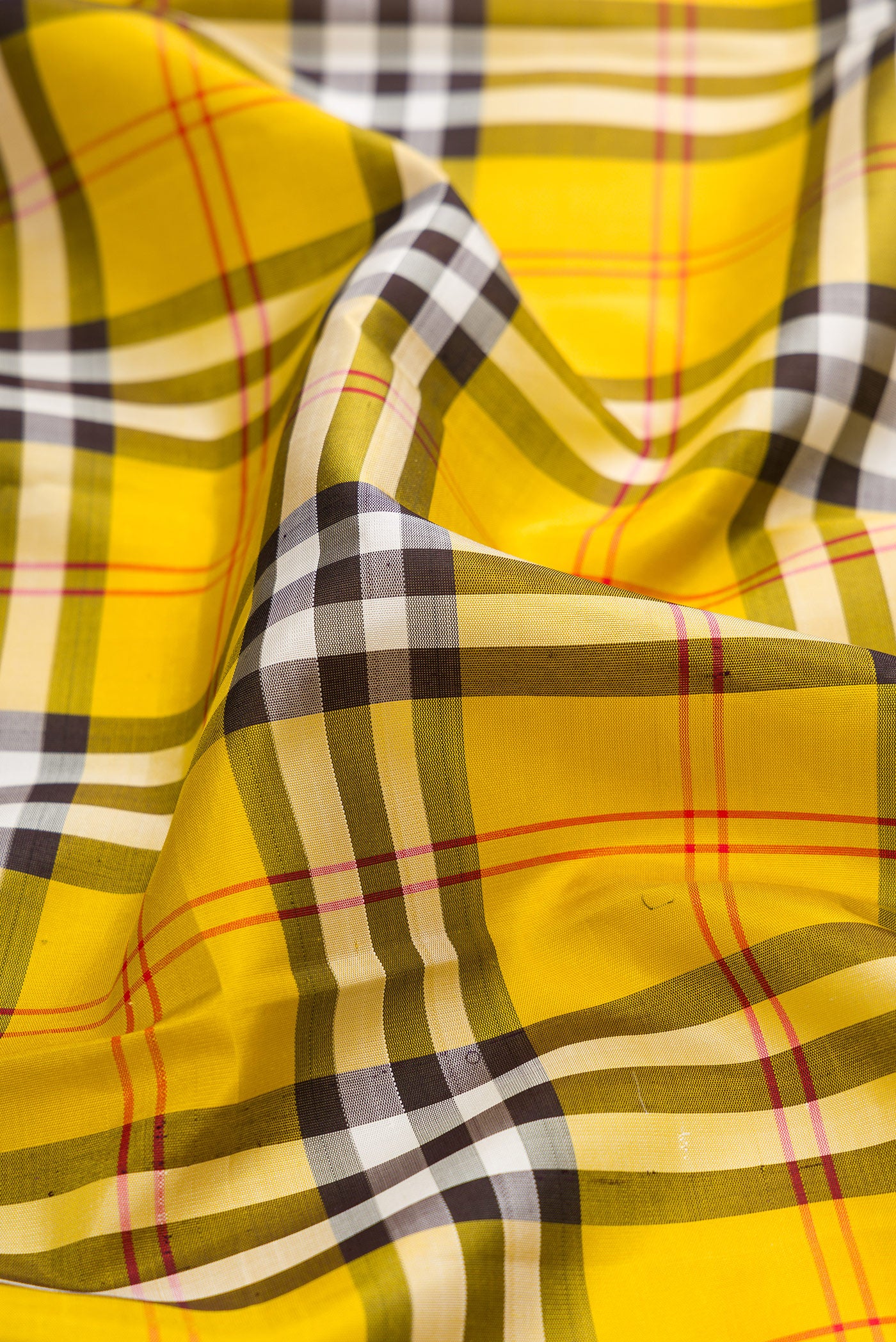 Close up of Pure Silk Pure Zari Yellow Kanjivaram Saree with Checked design on the body and Zari Border.  displaying folds