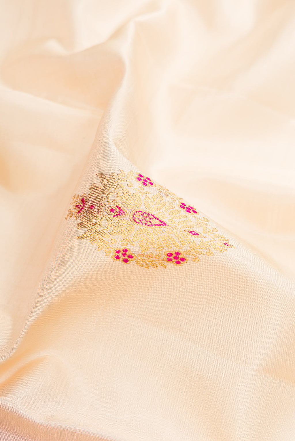 Close up of Off White Kanchipuram Silk Saree with Zari And Thread Butta on the body and Zari Border.  displaying folds