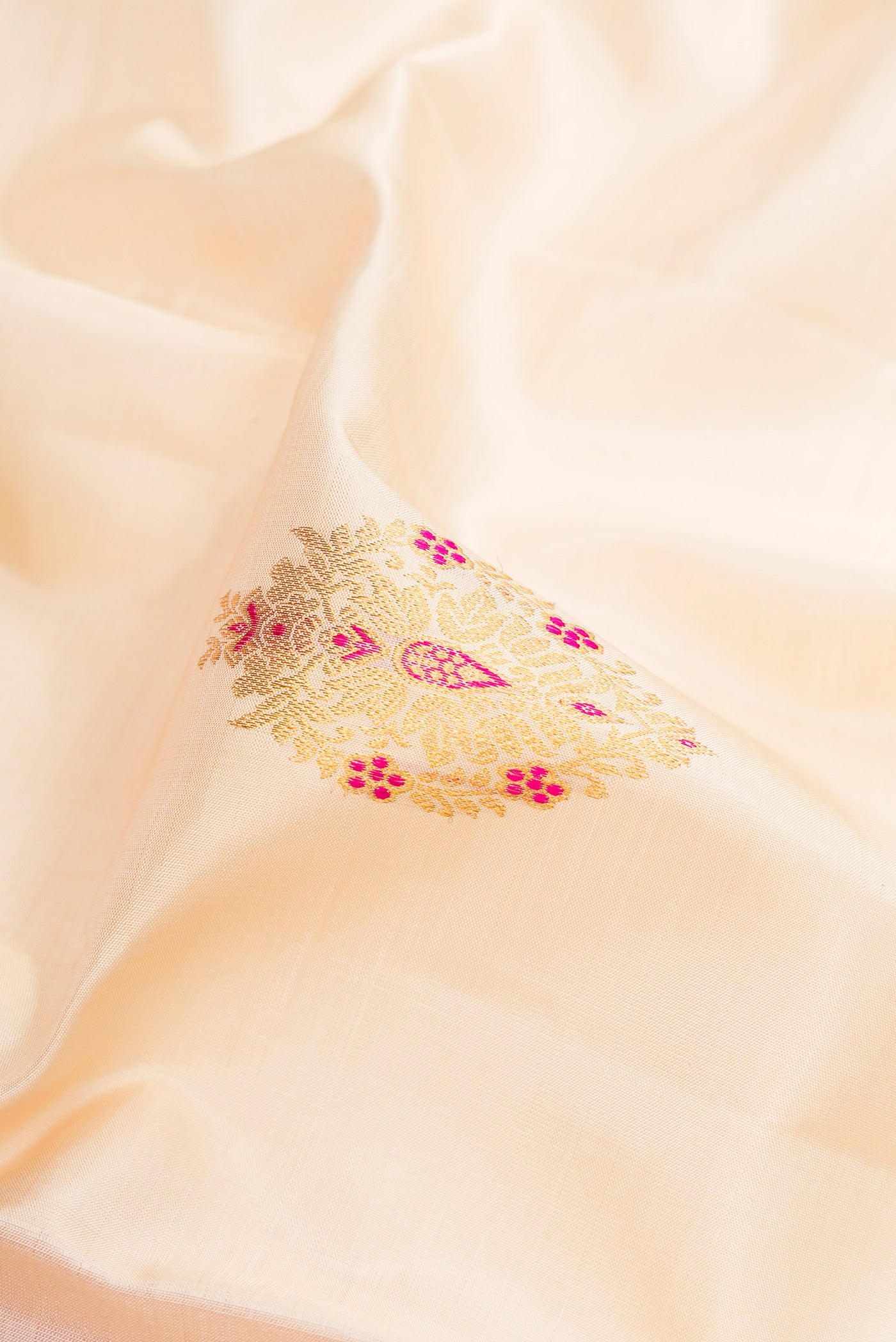 Close up of Off White Kanchipuram Silk Saree with Zari And Thread Butta on the body and Zari Border.  displaying folds
