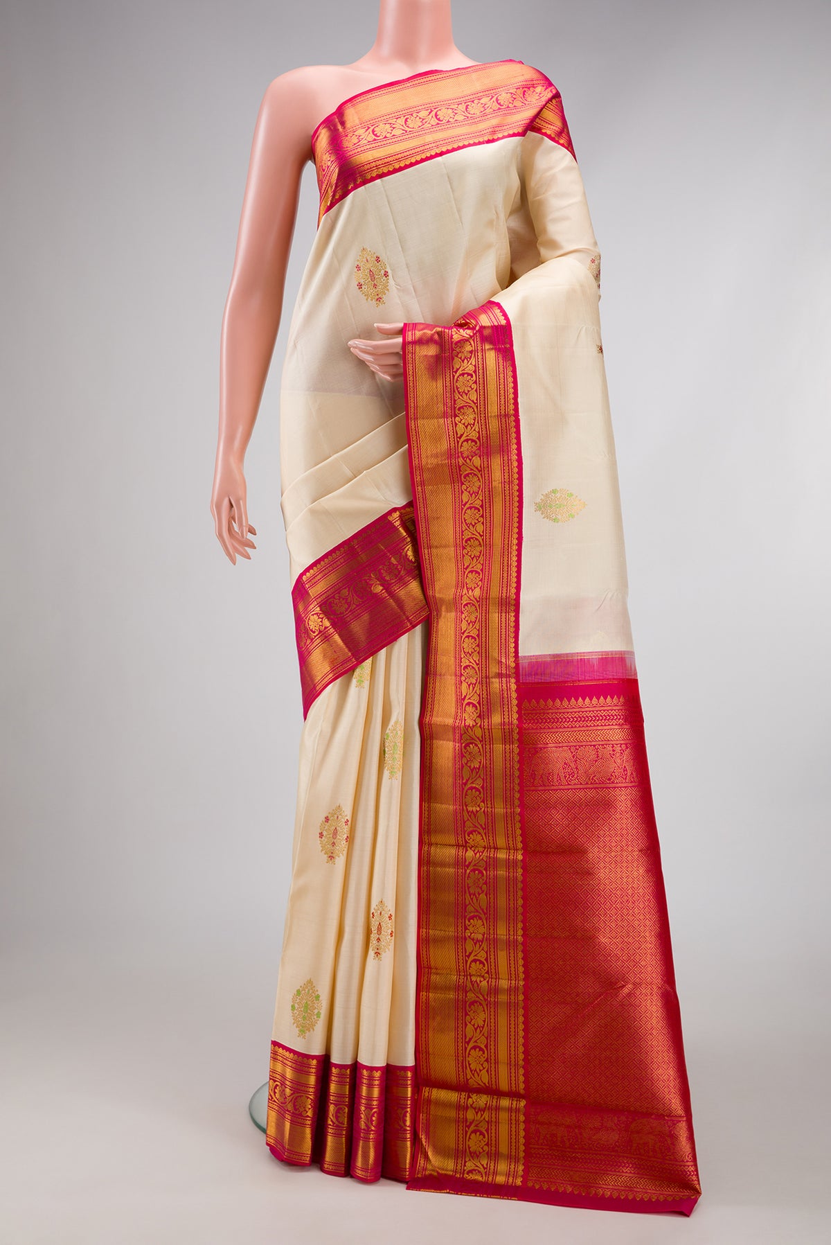 Off White Kanchipuram Silk Saree with Zari And Thread Butta on the body and Zari Border.  displayed on a mannequin