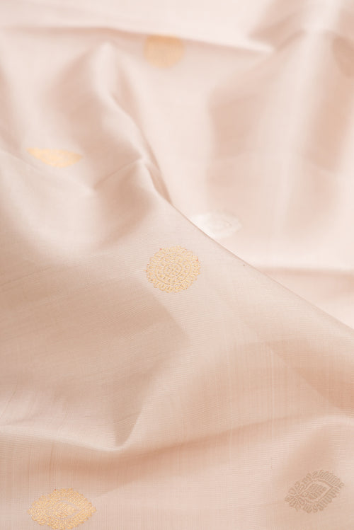 Close up of Beige Dual Tone Kanchipuram Silk Saree with Zari Butta on the body and Zari And Thread Border.  displaying folds