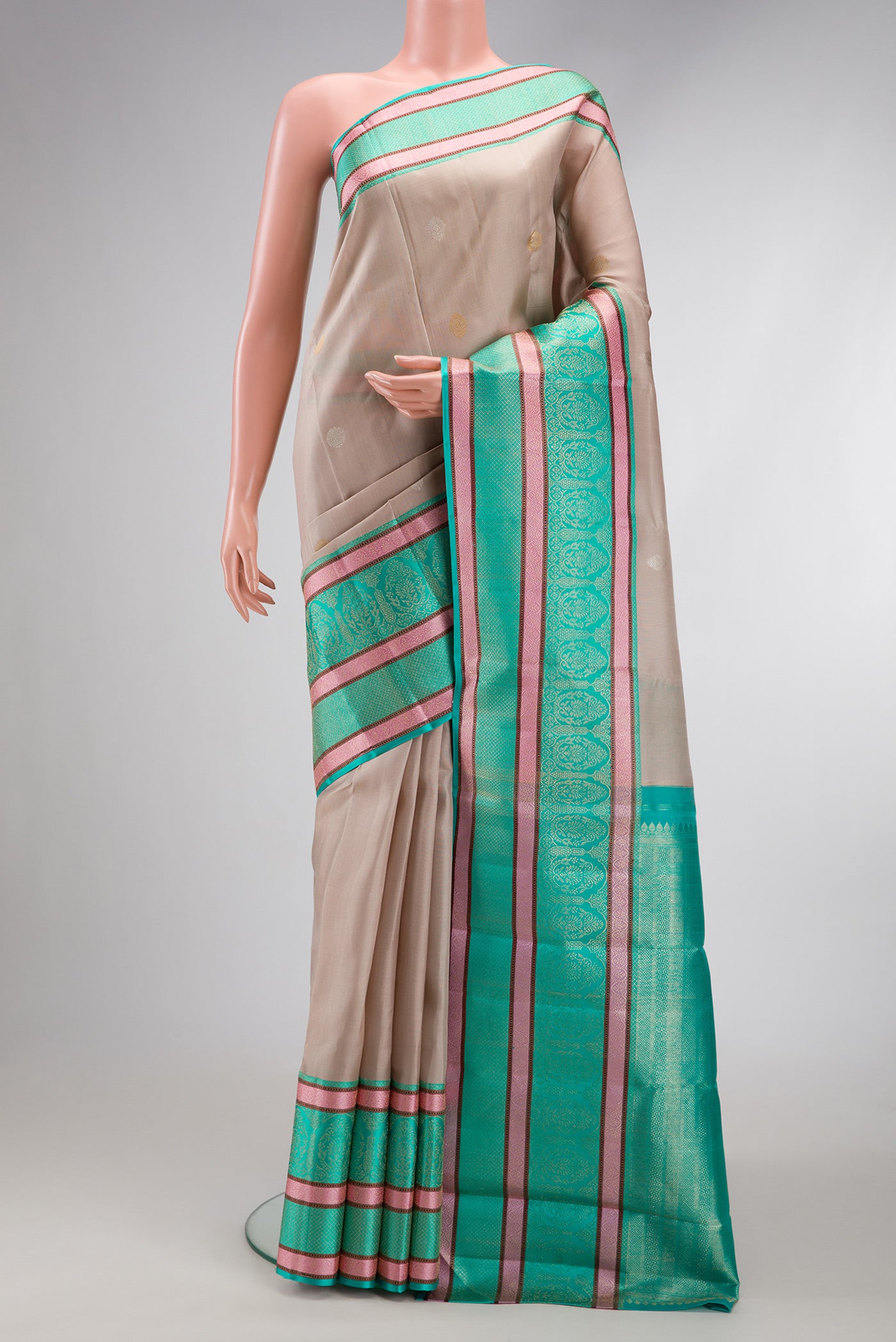 Beige Dual Tone Kanchipuram Silk Saree with Zari Butta on the body and Zari And Thread Border.  displayed on a mannequin