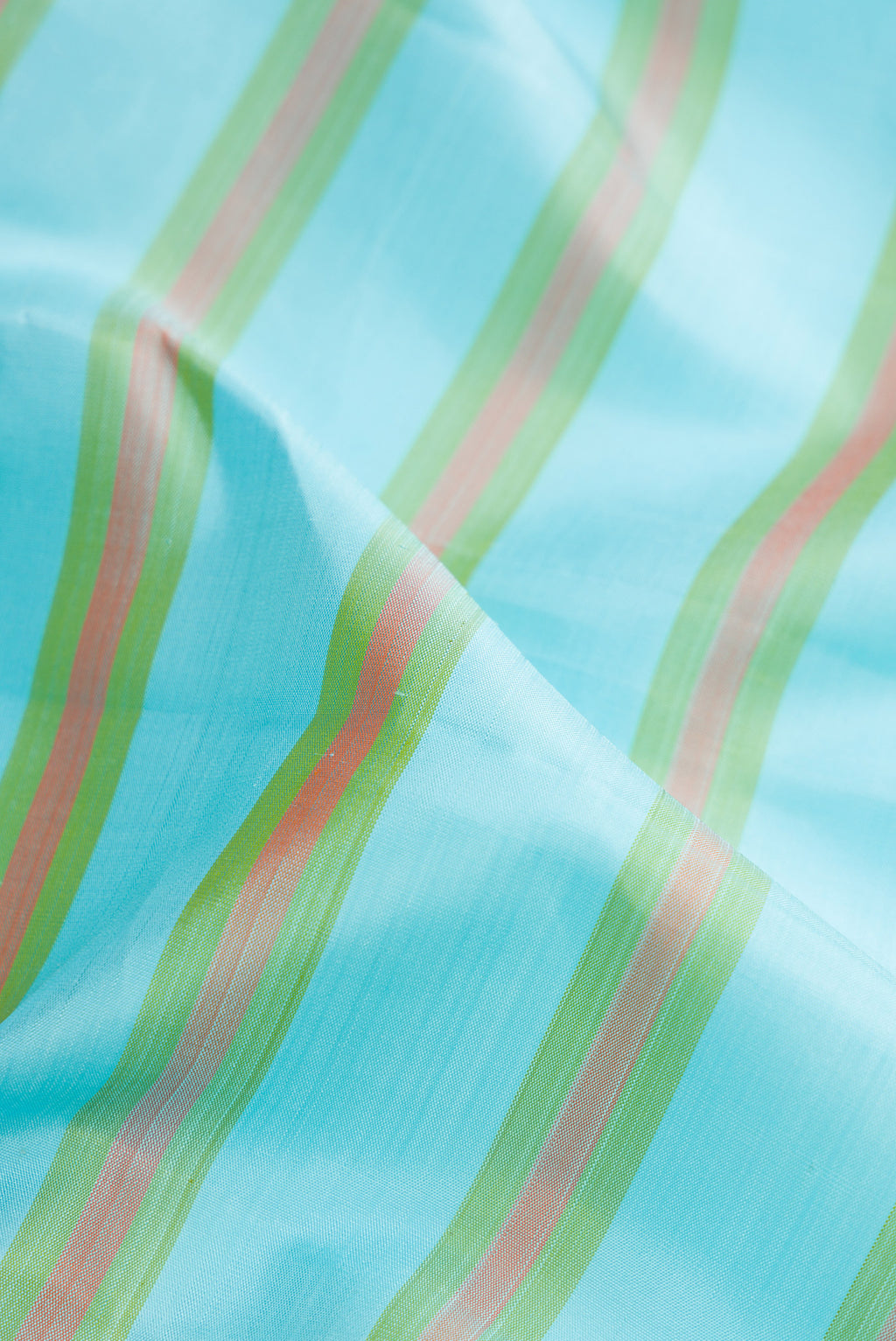 Close up of Sky Blue Kanchipuram Silk Saree with Stripes on the body and Zari Border.  displaying folds