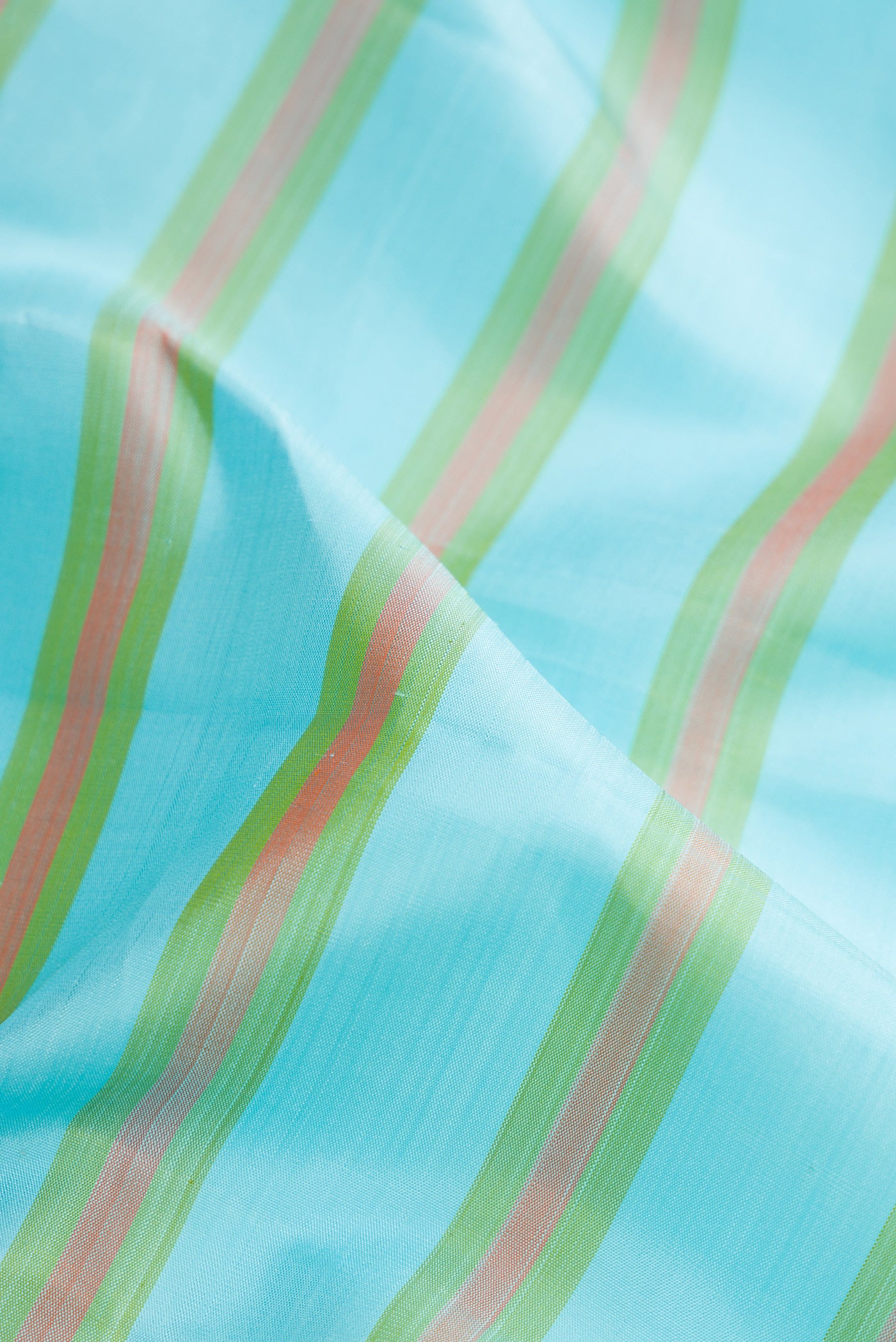 Close up of Sky Blue Kanchipuram Silk Saree with Stripes on the body and Zari Border.  displaying folds