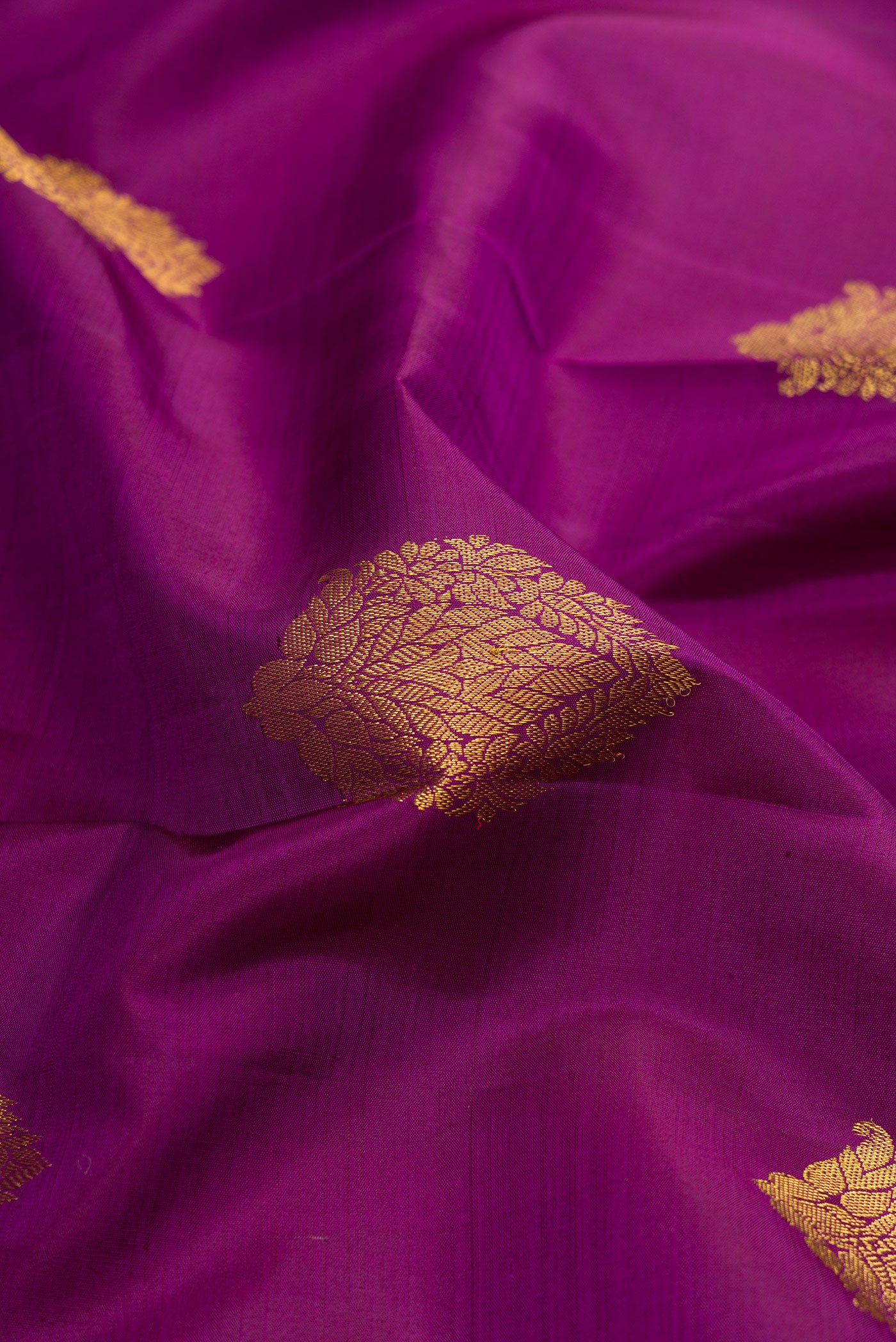 Close up of Purple Kanchipuram Silk Saree with Zari Butta on the body and Zari Border.  displaying folds