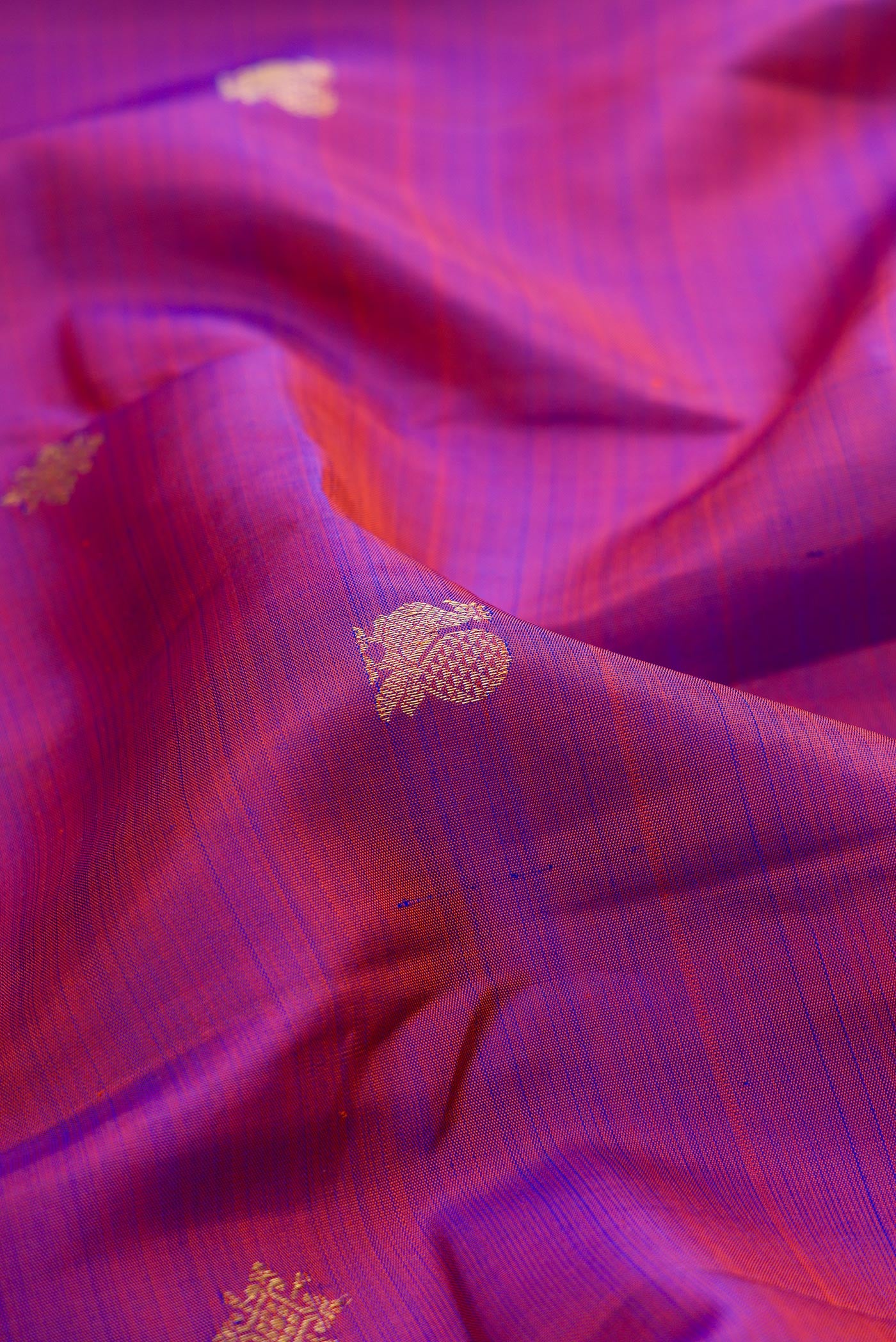 Close up of Purple Kanchipuram Silk Saree with Zari Butta on the body and Zari Border.  displaying folds