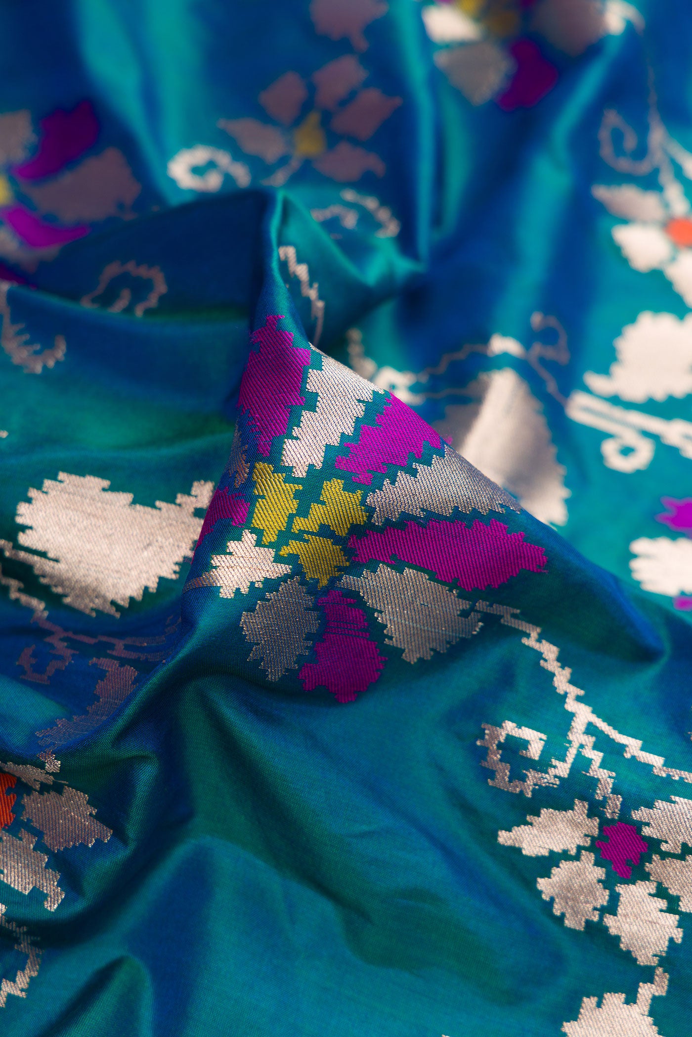 Close up of Peacock Blue Dual Tone Banarasi Silk Saree with Zari Butta on the body and Zari Border.  displaying folds
