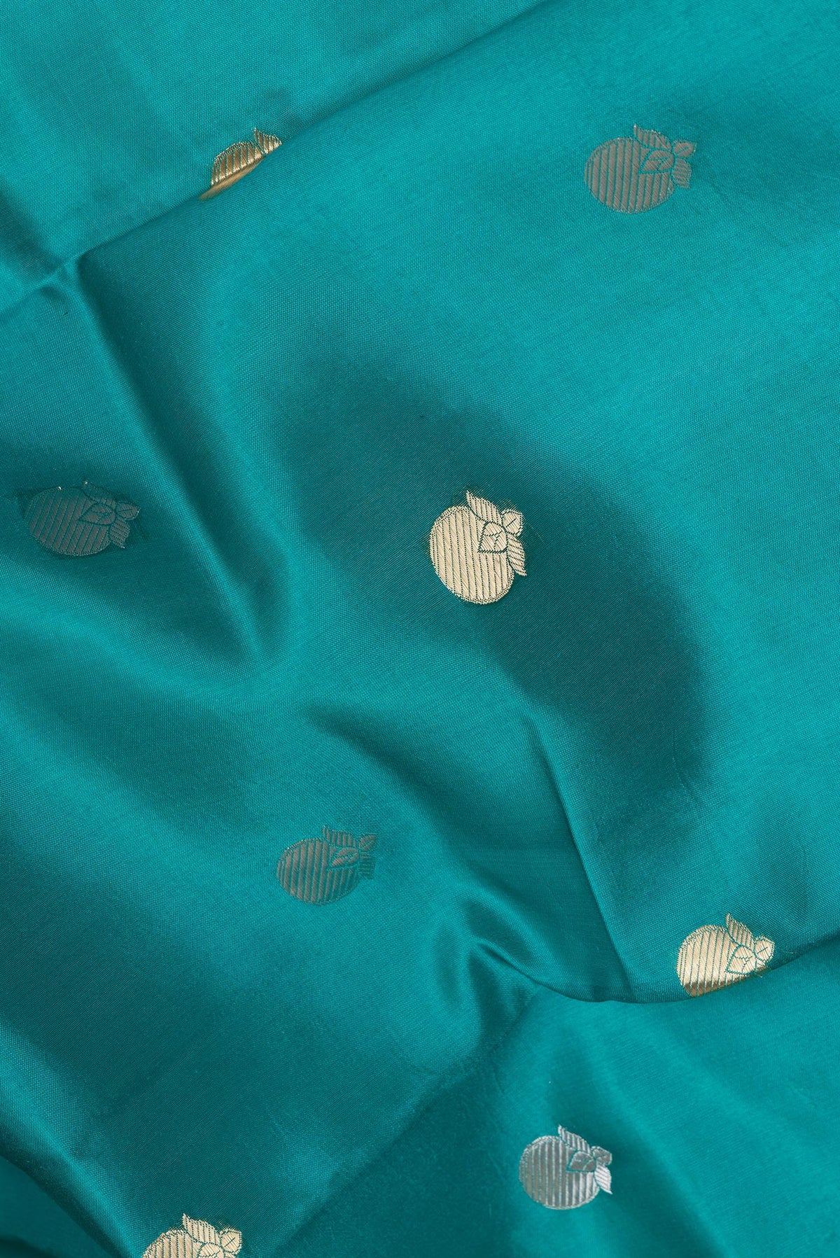Close up of Peacock Blue Tussar Silk Saree with Zari Butta on the body and Zari Border.  displaying folds