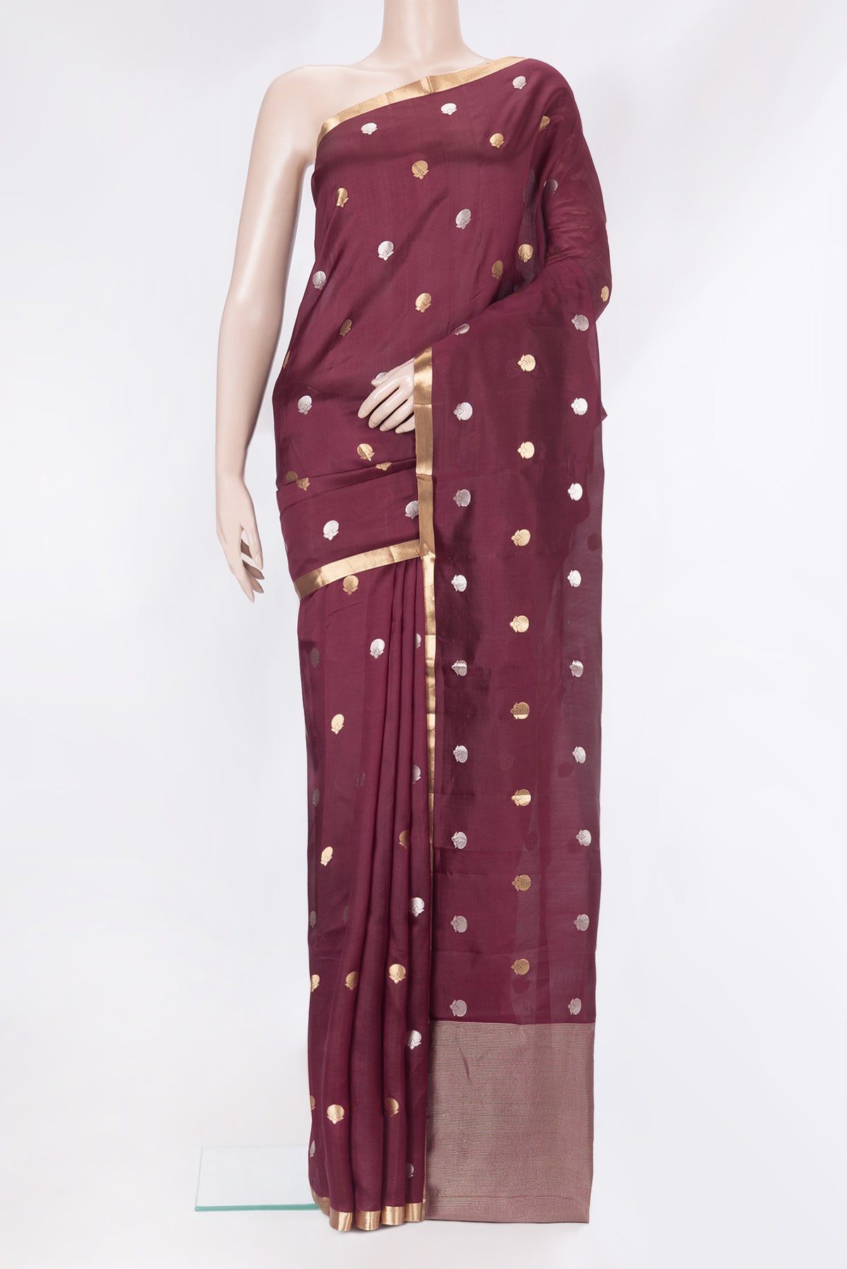 Maroon Tussar Silk Saree with Zari Butta on the body and Zari Border.  displayed on a mannequin