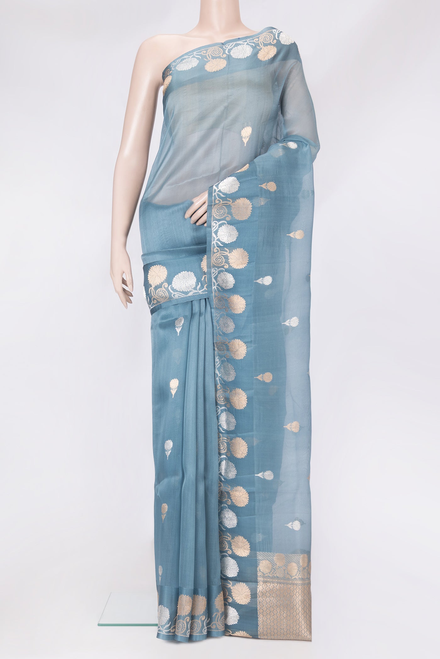 Blue Grey Organza Silk Saree with Zari Butta on the body and Zari Border.  displayed on a mannequin