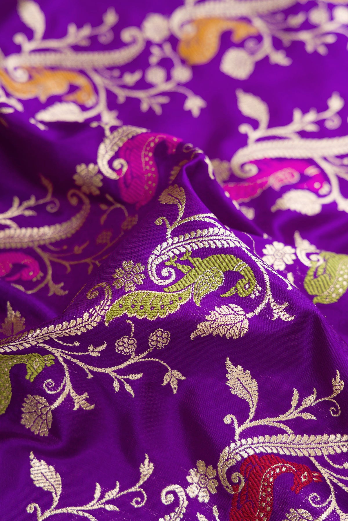Close up of Violet Dual Tone Banarasi Silk Saree with Zari Butta on the body and Zari Border.  displaying folds