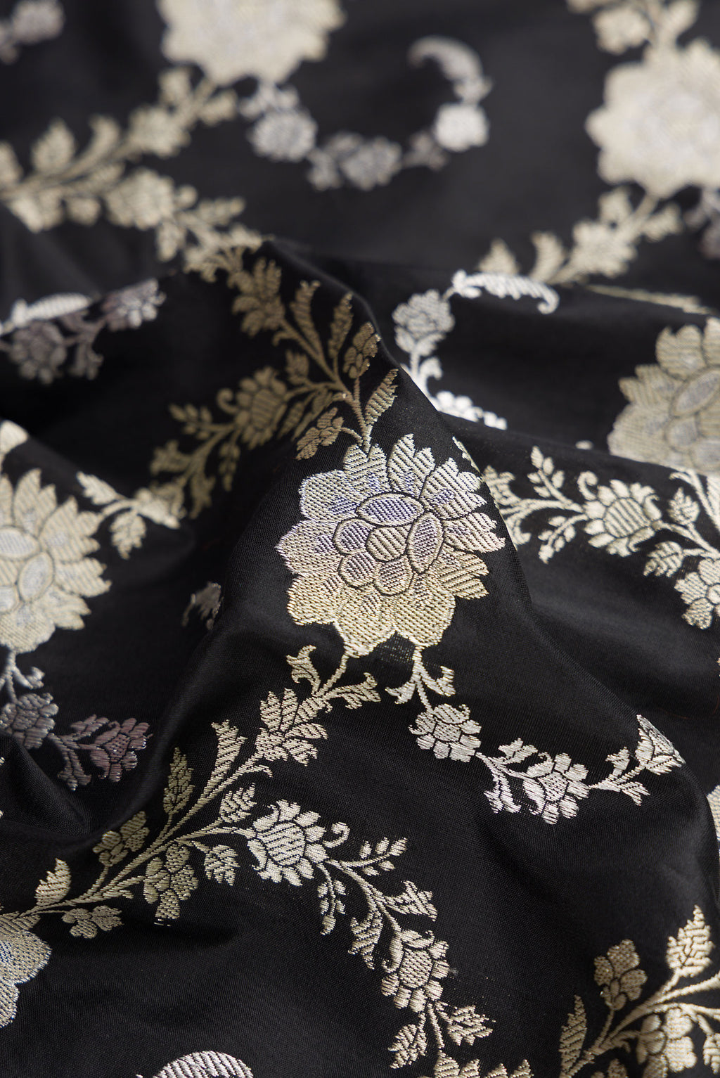 Close up of Black Dual Tone Banarasi Silk Saree with Zari Butta on the body and Zari Border.  displaying folds