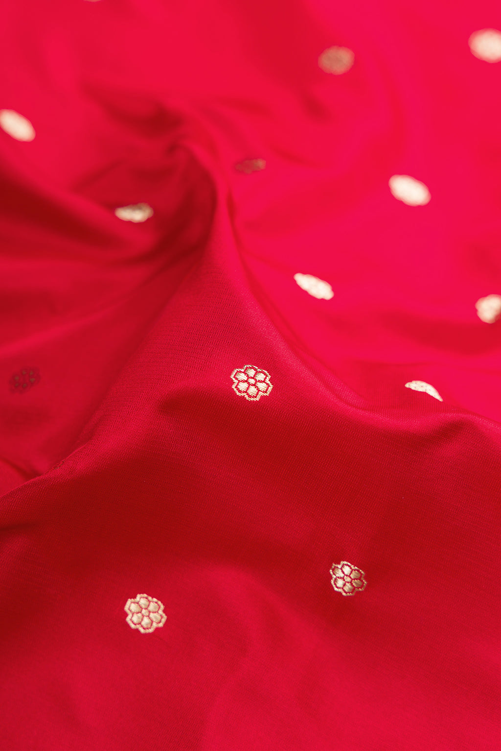 Close up of Red Dual Tone Banarasi Silk Saree with Zari Butta on the body and Zari Border.  displaying folds
