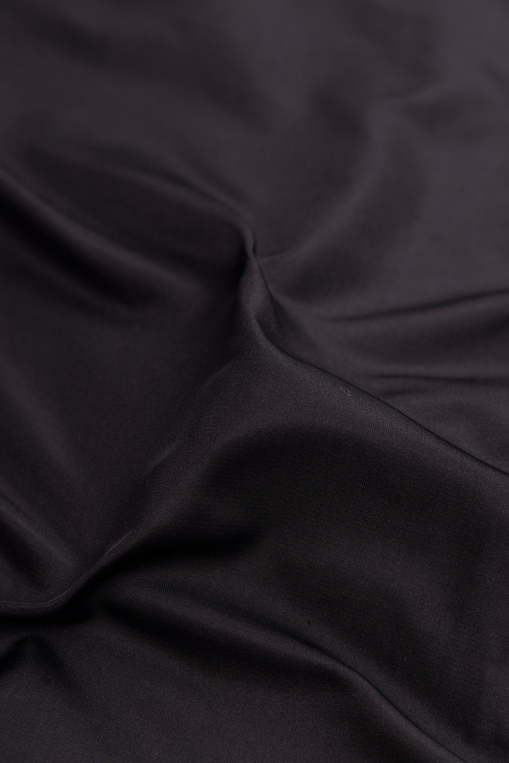 Close up of Black Banarasi Silk Saree with Plain Body and Zari Border.  displaying folds