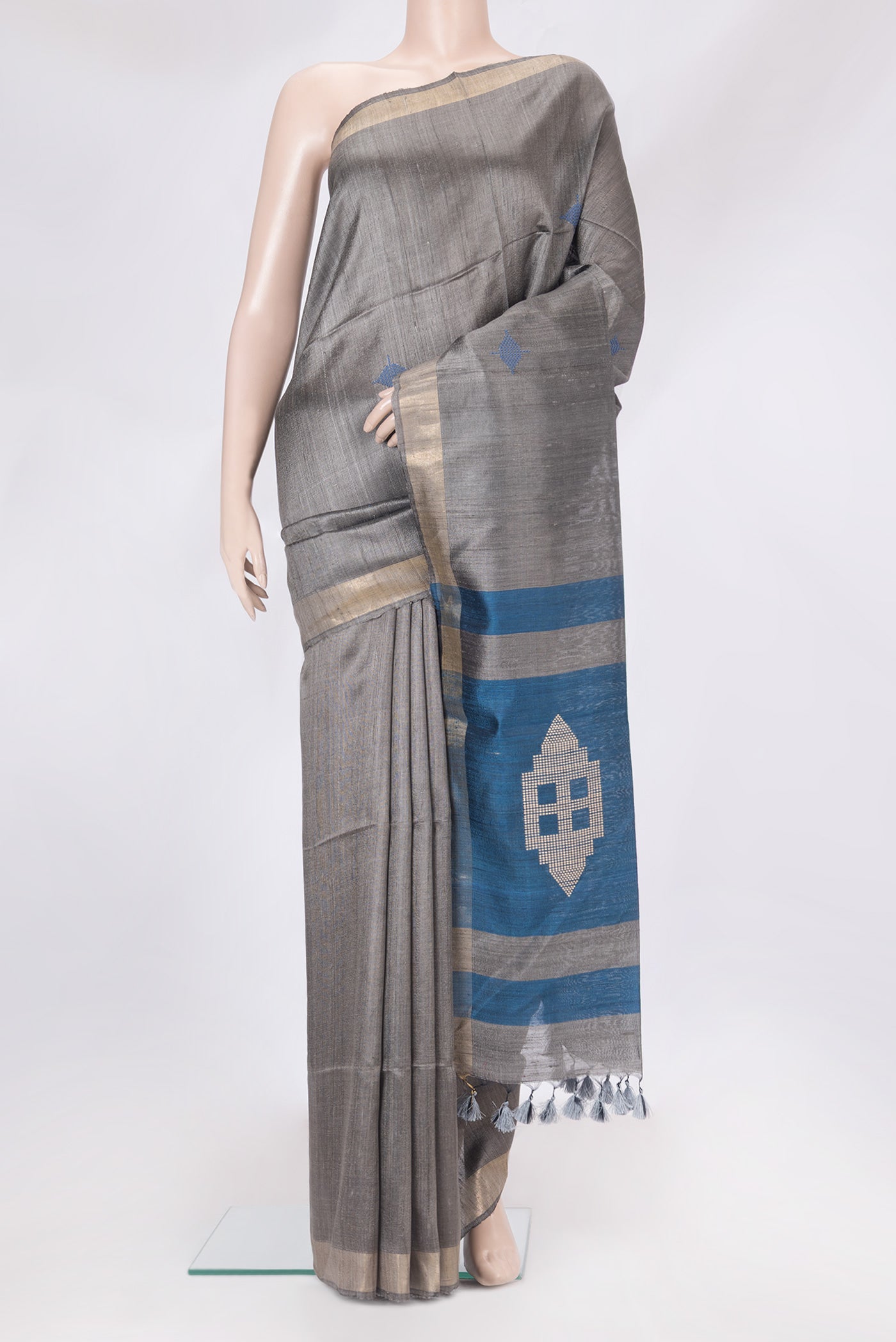 Grey Tussar Silk Saree with Thread Butta on the body and Zari Border.  displayed on a mannequin