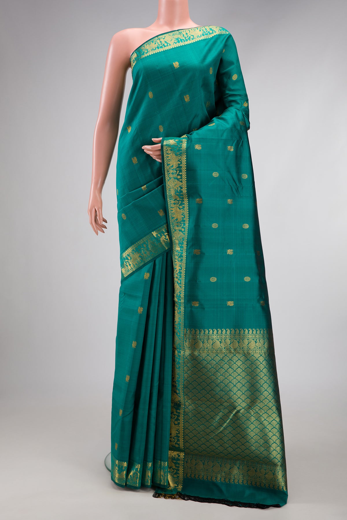 Teal Kanjivaram Silk Saree with Zari Butta on the body and Zari Border.  displayed on a mannequin
