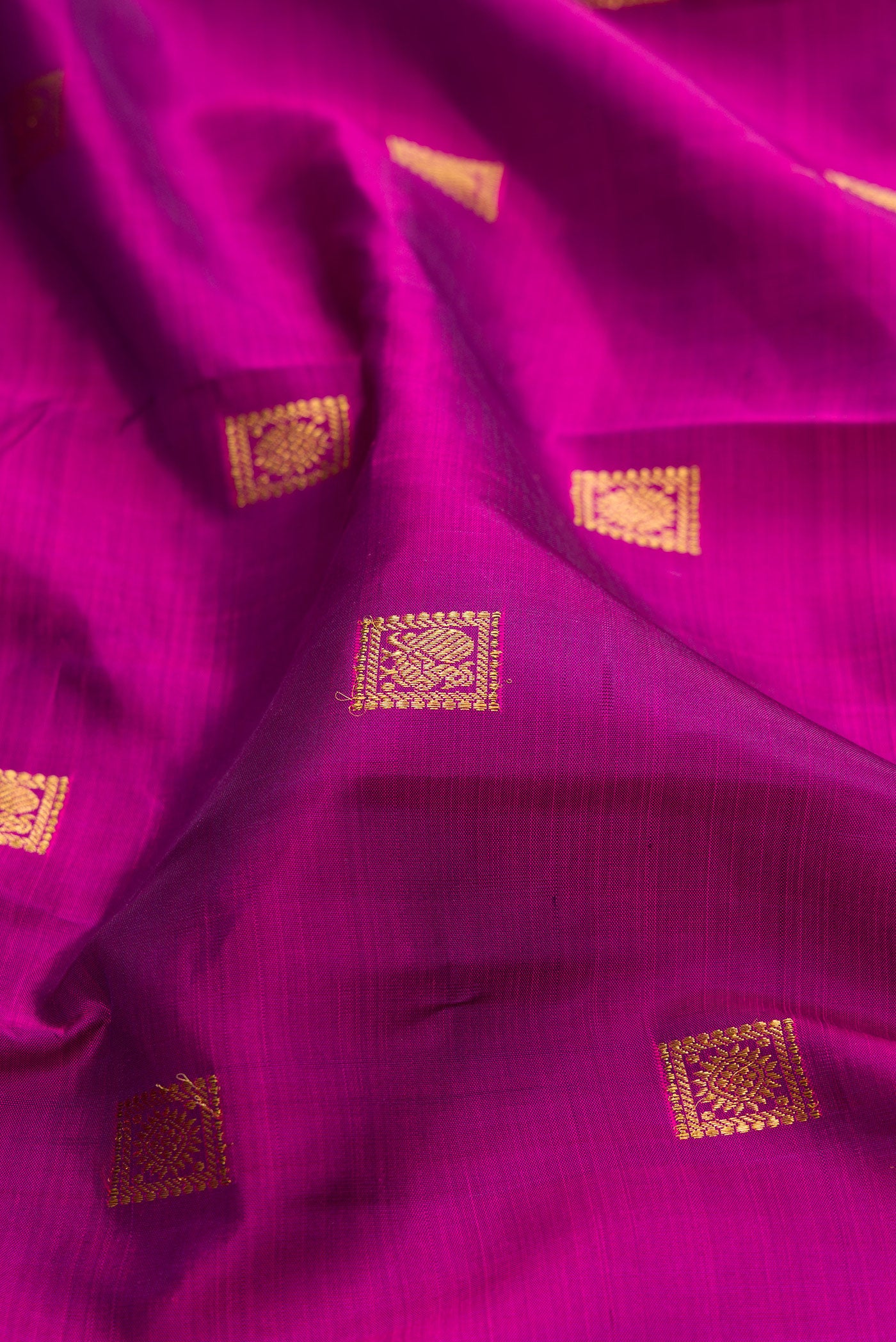 Close up of Purple Kanjivaram Silk Saree with Zari Butta on the body and Zari Border.  displaying folds