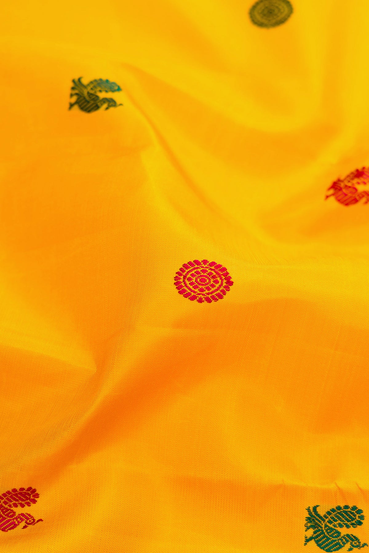 Close up of Yellow Kanjivaram Silk Saree with Thread Butta on the body and Zari Border.  displaying folds